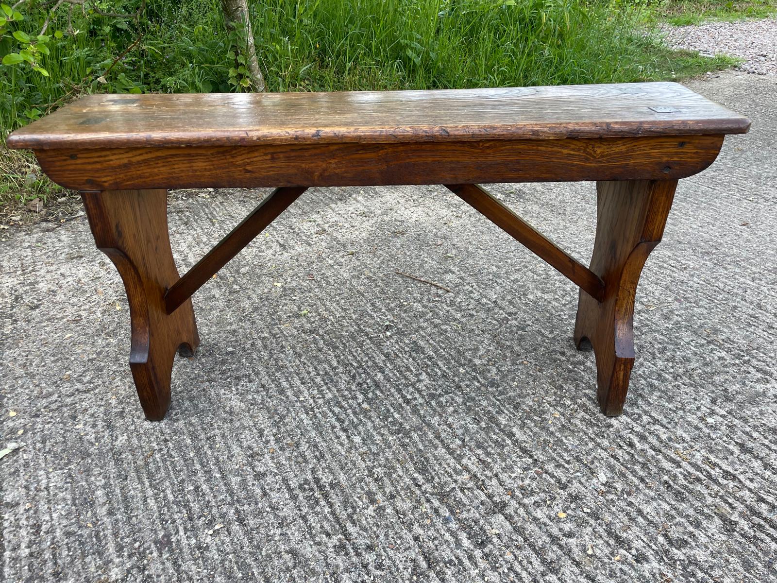 Wooden bench on a concrete surface with grass in the background
