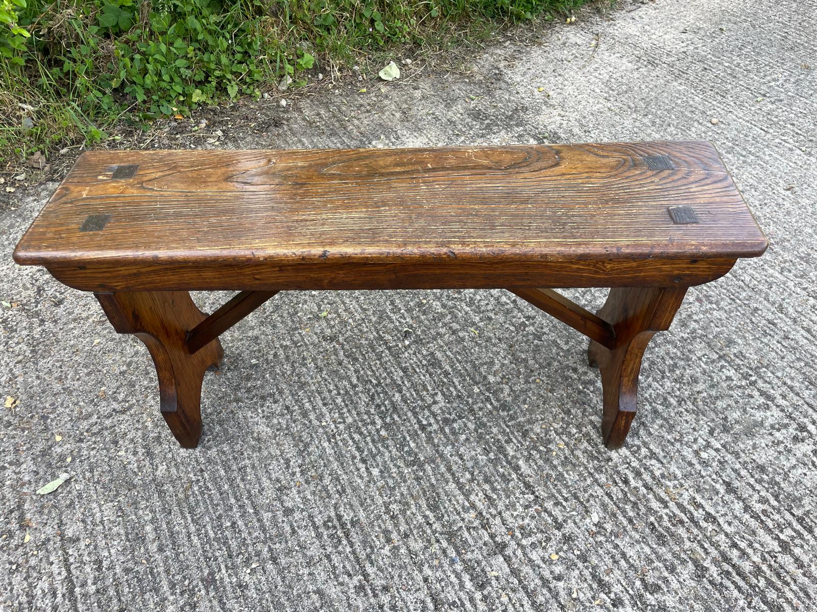 Wooden bench on a concrete surface with grass in the background