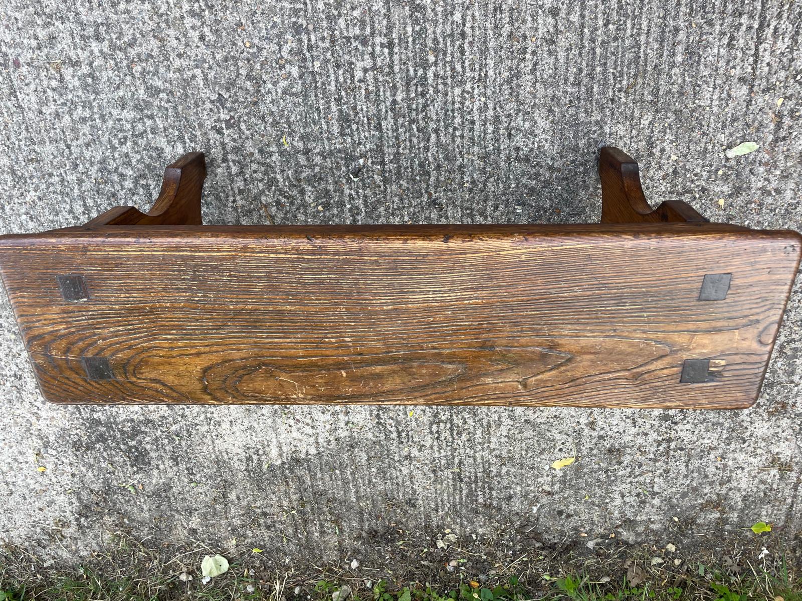 Wooden bench with metal brackets on a concrete surface