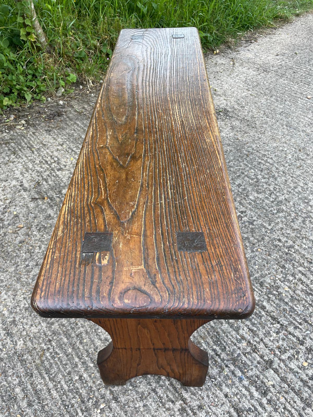 Wooden bench on a concrete surface with grass in the background