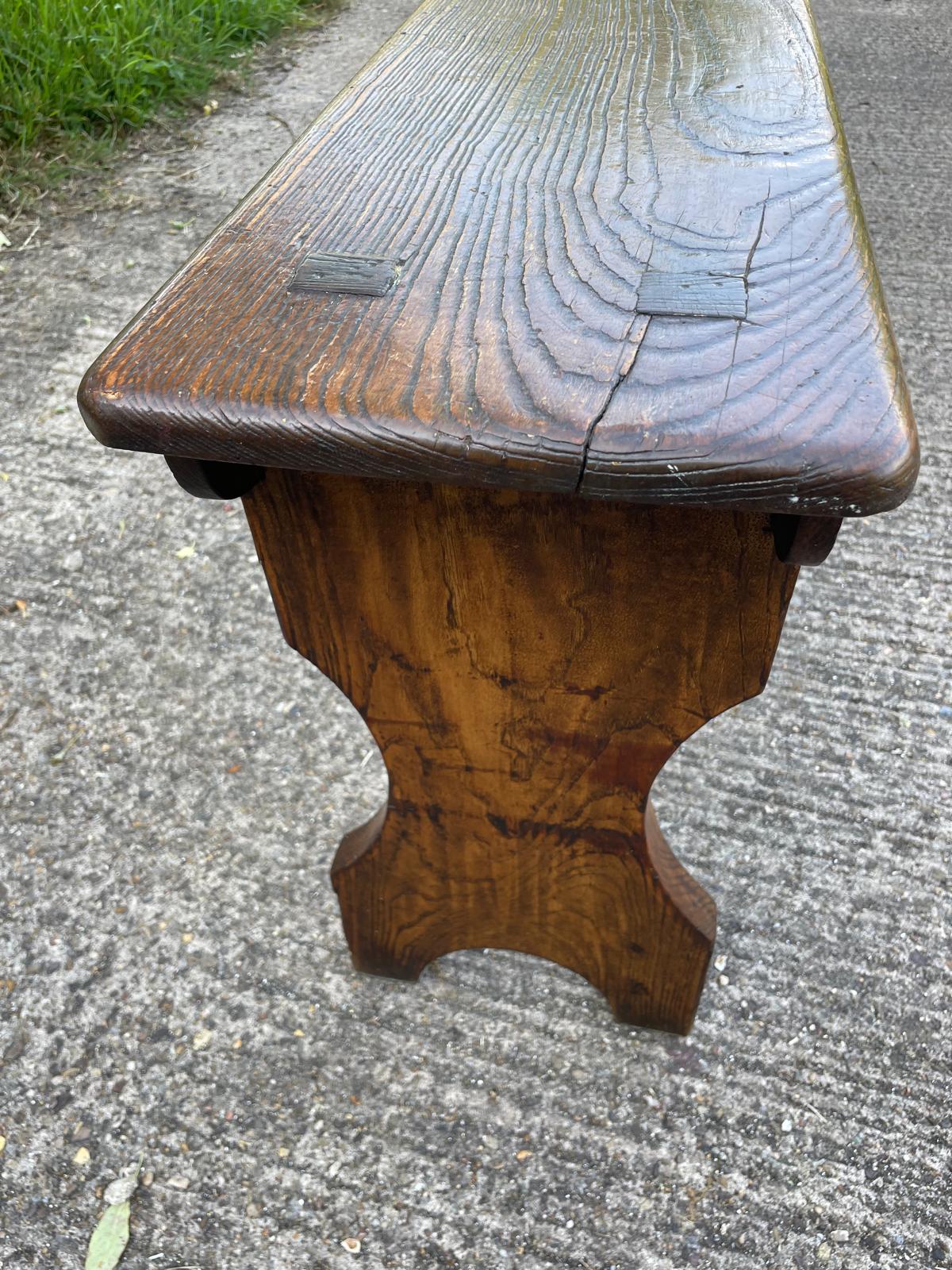 Wooden bench with a textured surface on a concrete ground