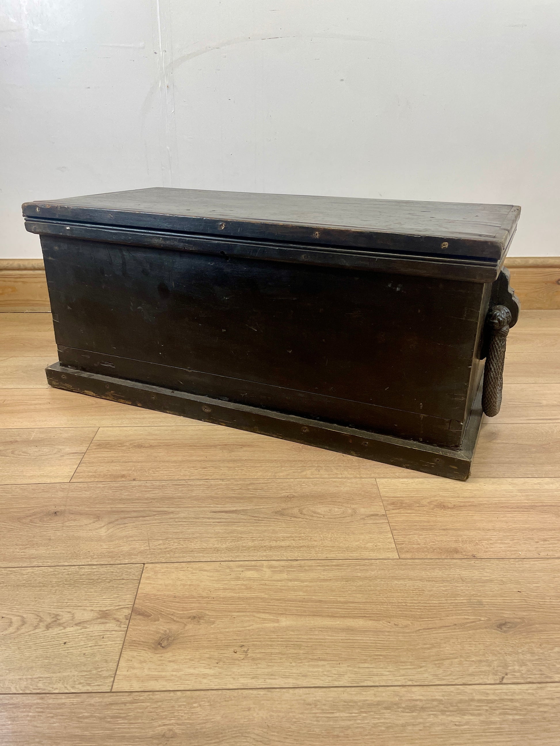 Wooden trunk on a wooden floor with a white wall background