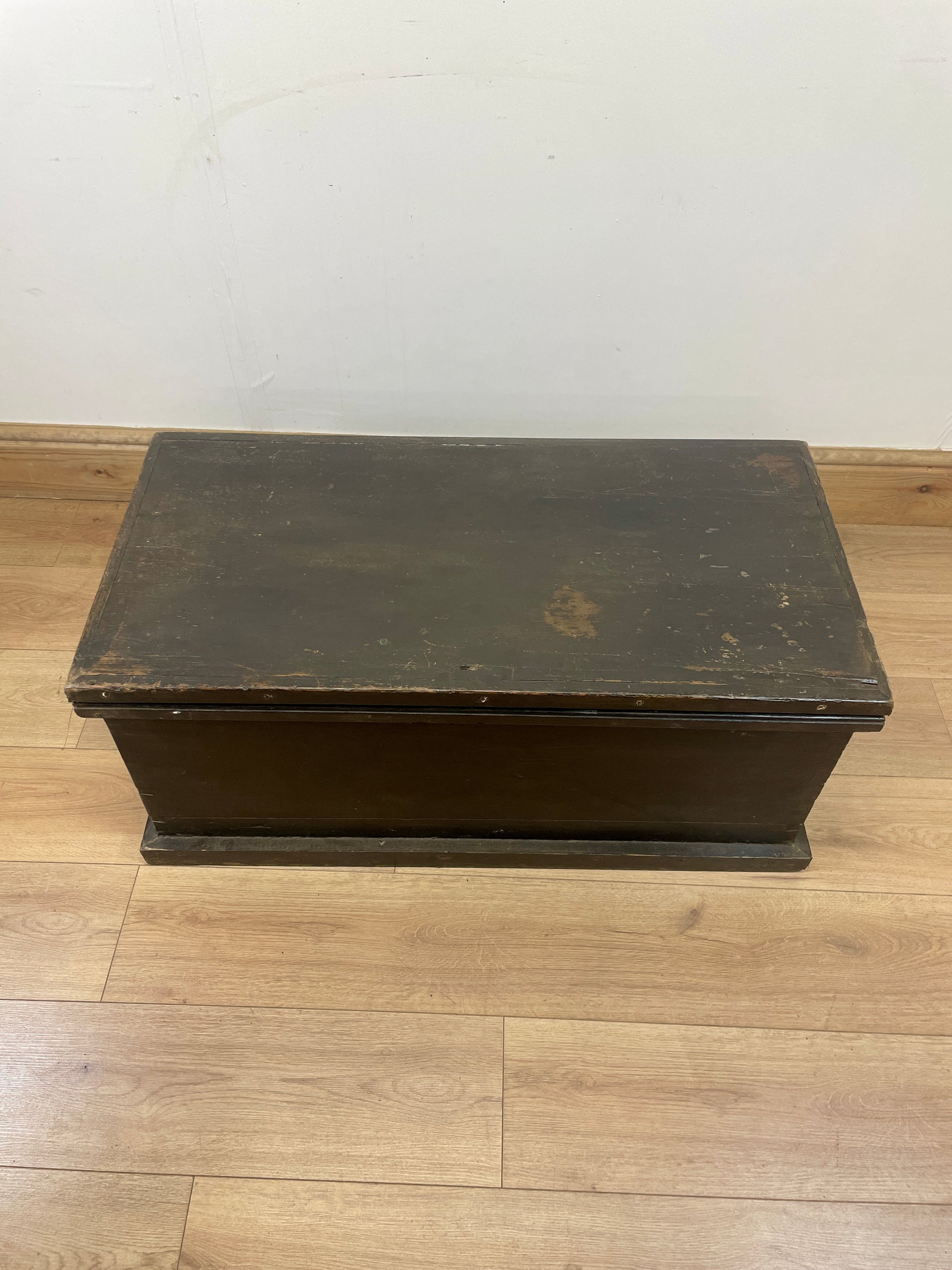 Vintage wooden step stool on a wooden floor with a white wall background