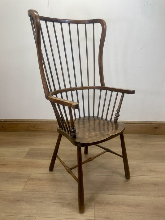 Wooden chair with a spindle back on a wooden floor against a white wall
