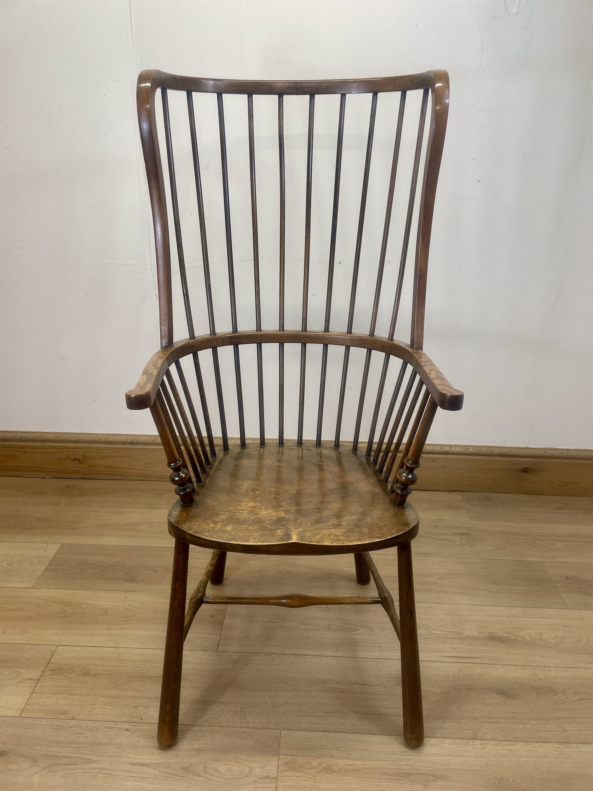 Wooden chair with spindle back on a wooden floor against a white wall