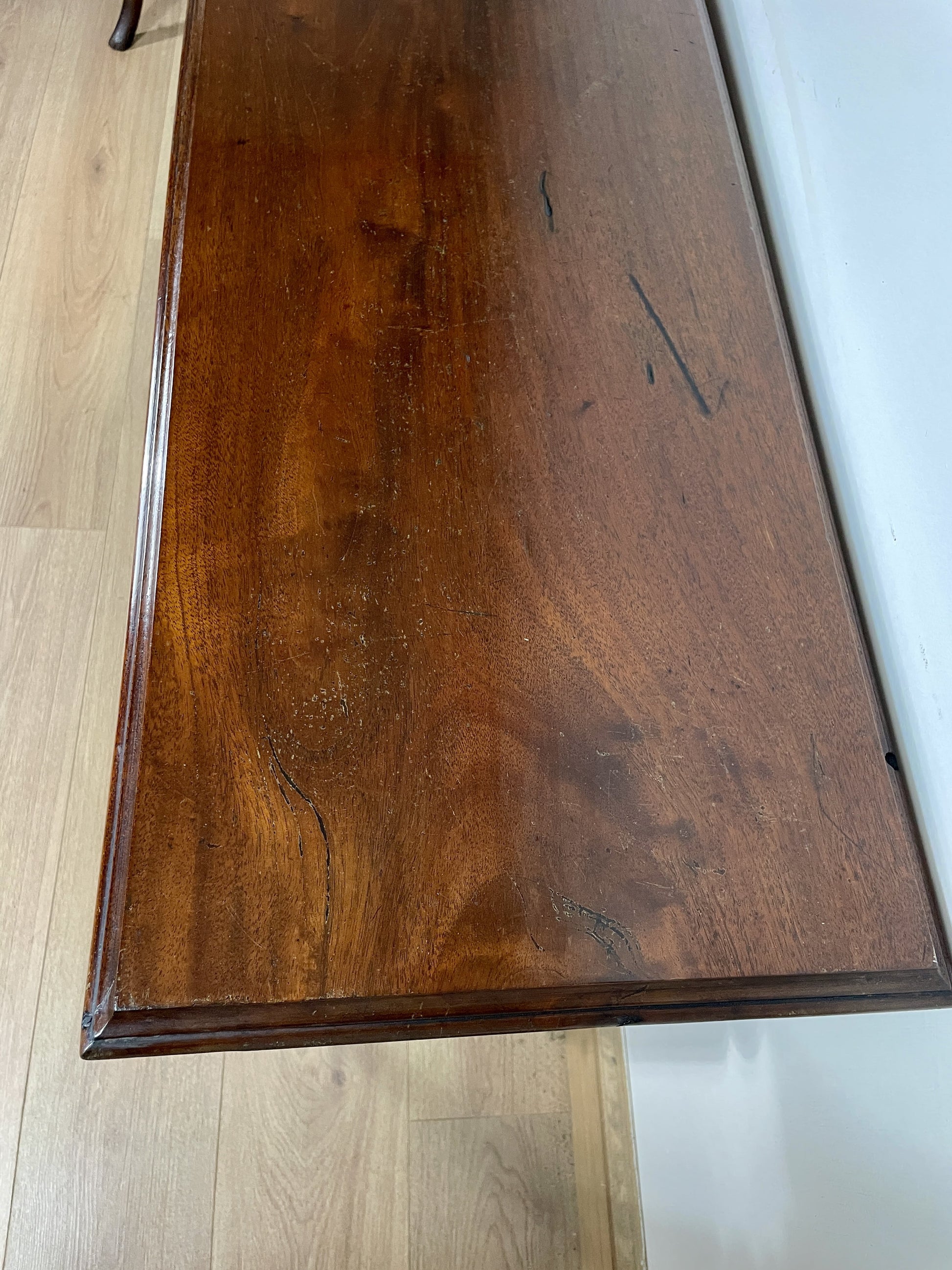 Wooden surface with a visible grain pattern on a light wooden floor.