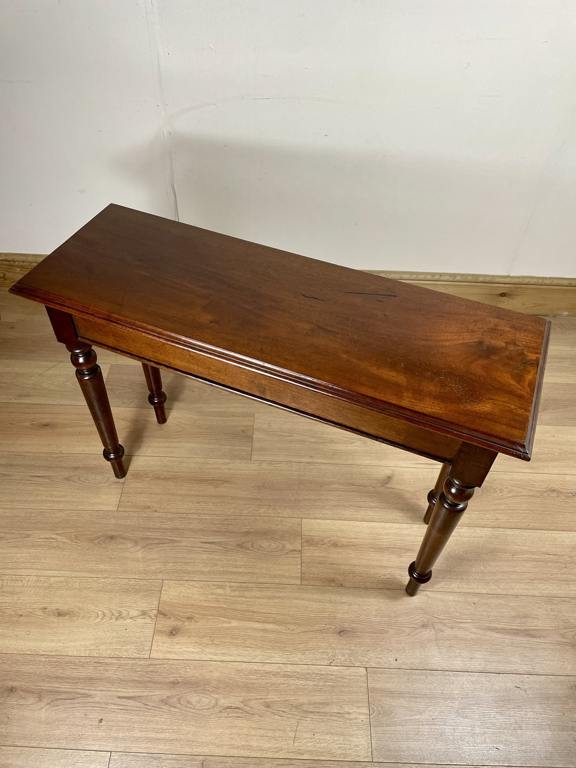 Wooden table on a wooden floor with a plain wall background