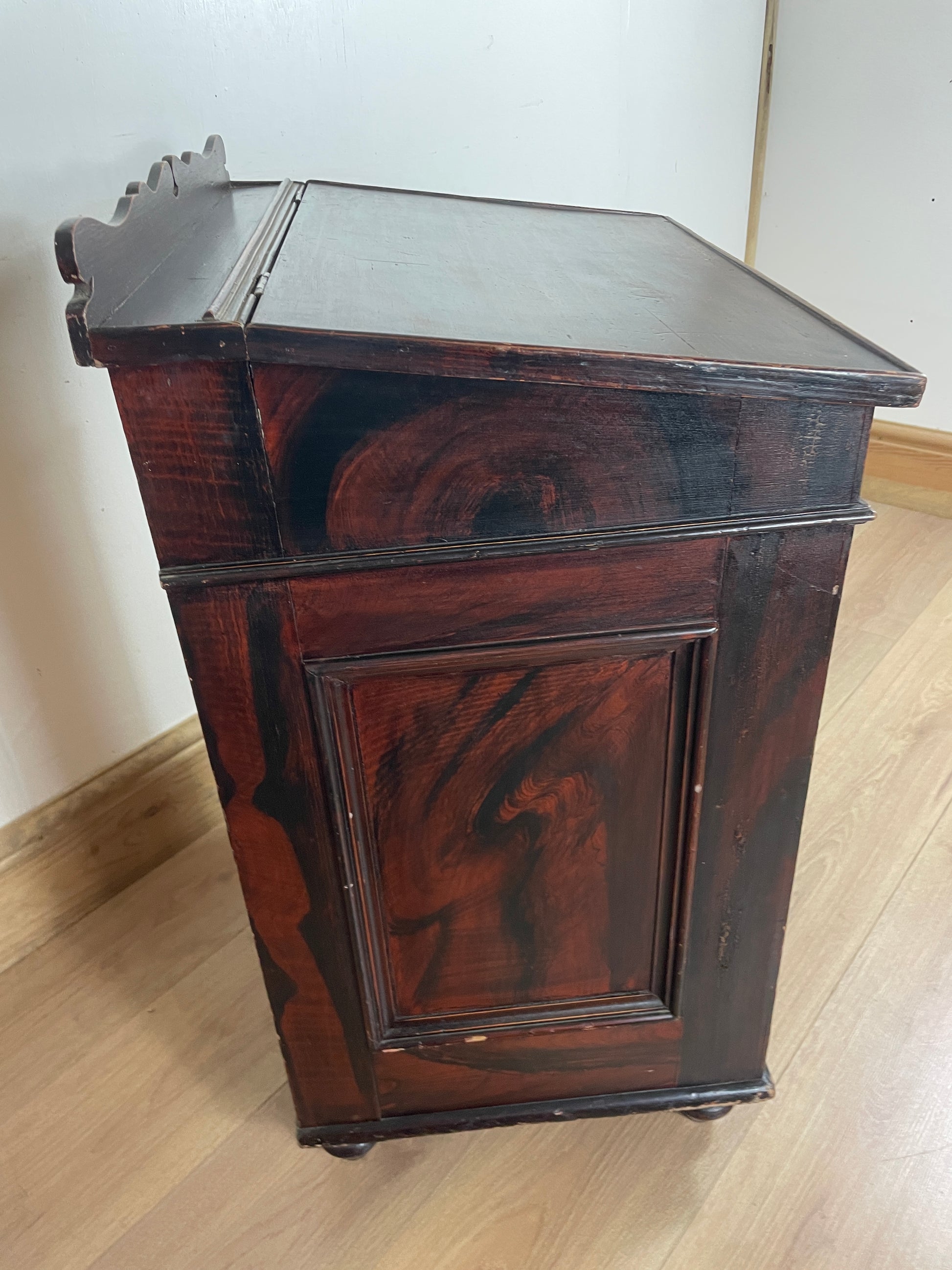 Wooden box with a glass front on a light wooden floor.