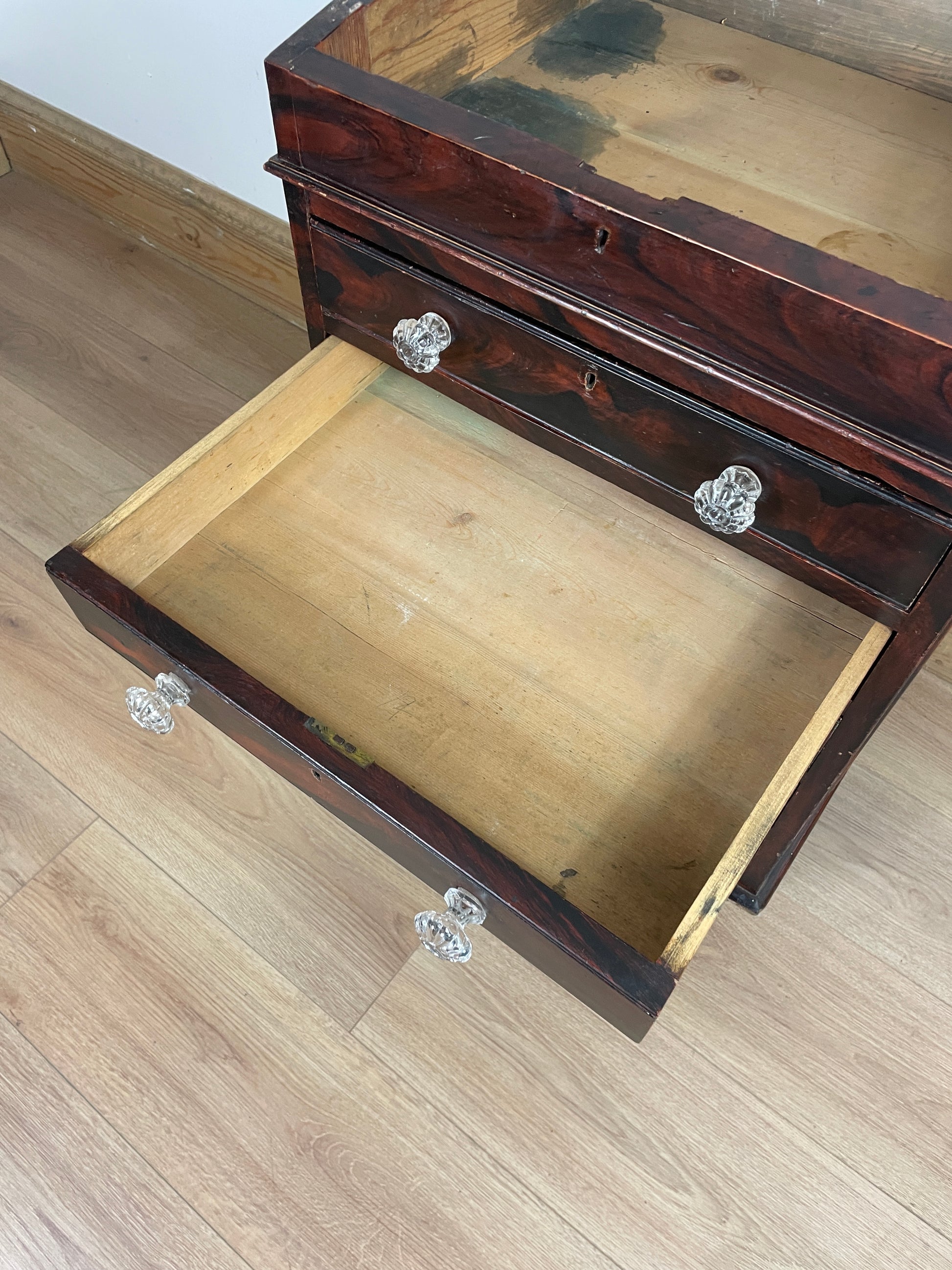 Wooden jewelry box with glass knobs on a wooden surface