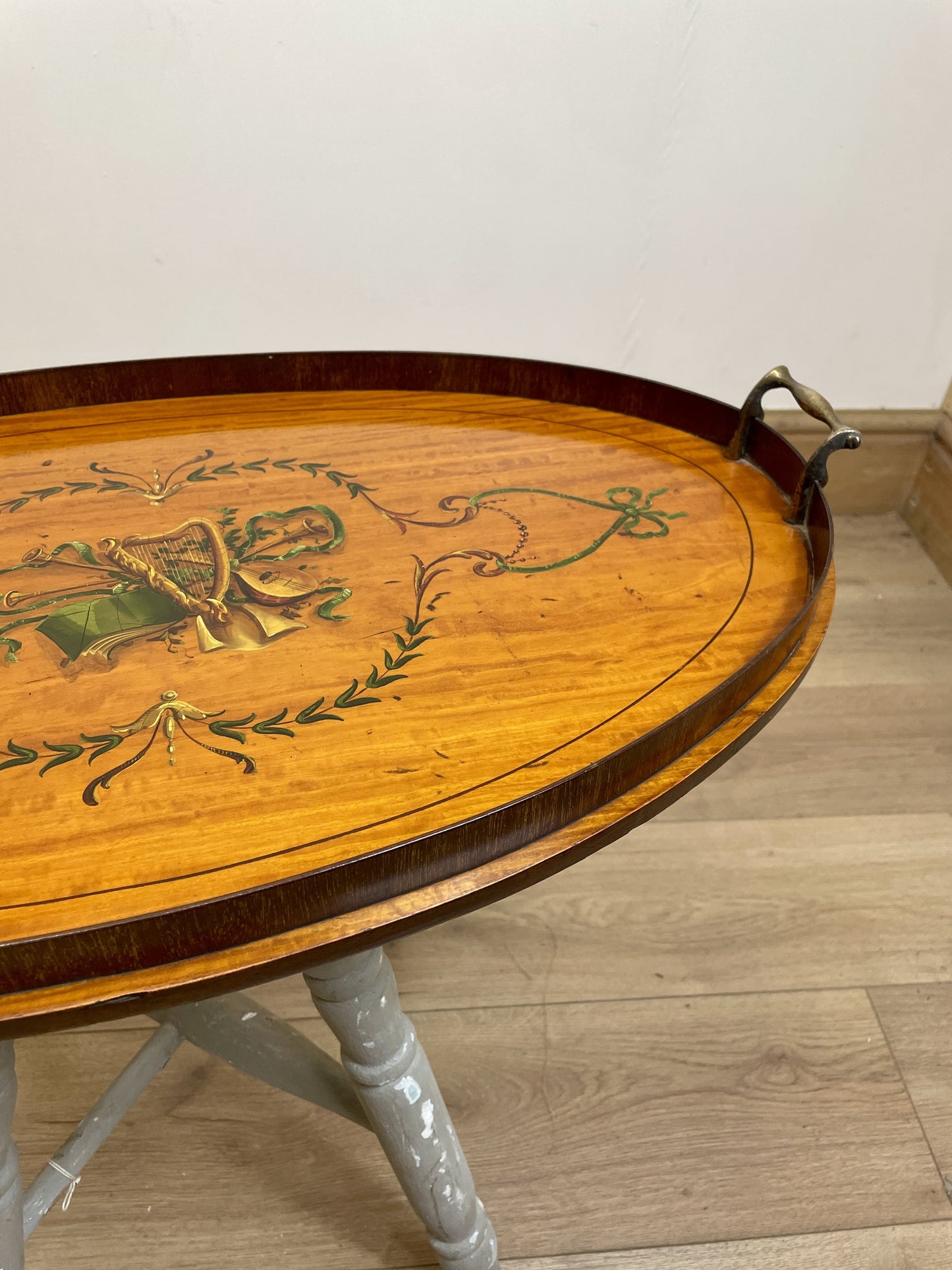 Wooden tray with decorative patterns on a light wooden floor.