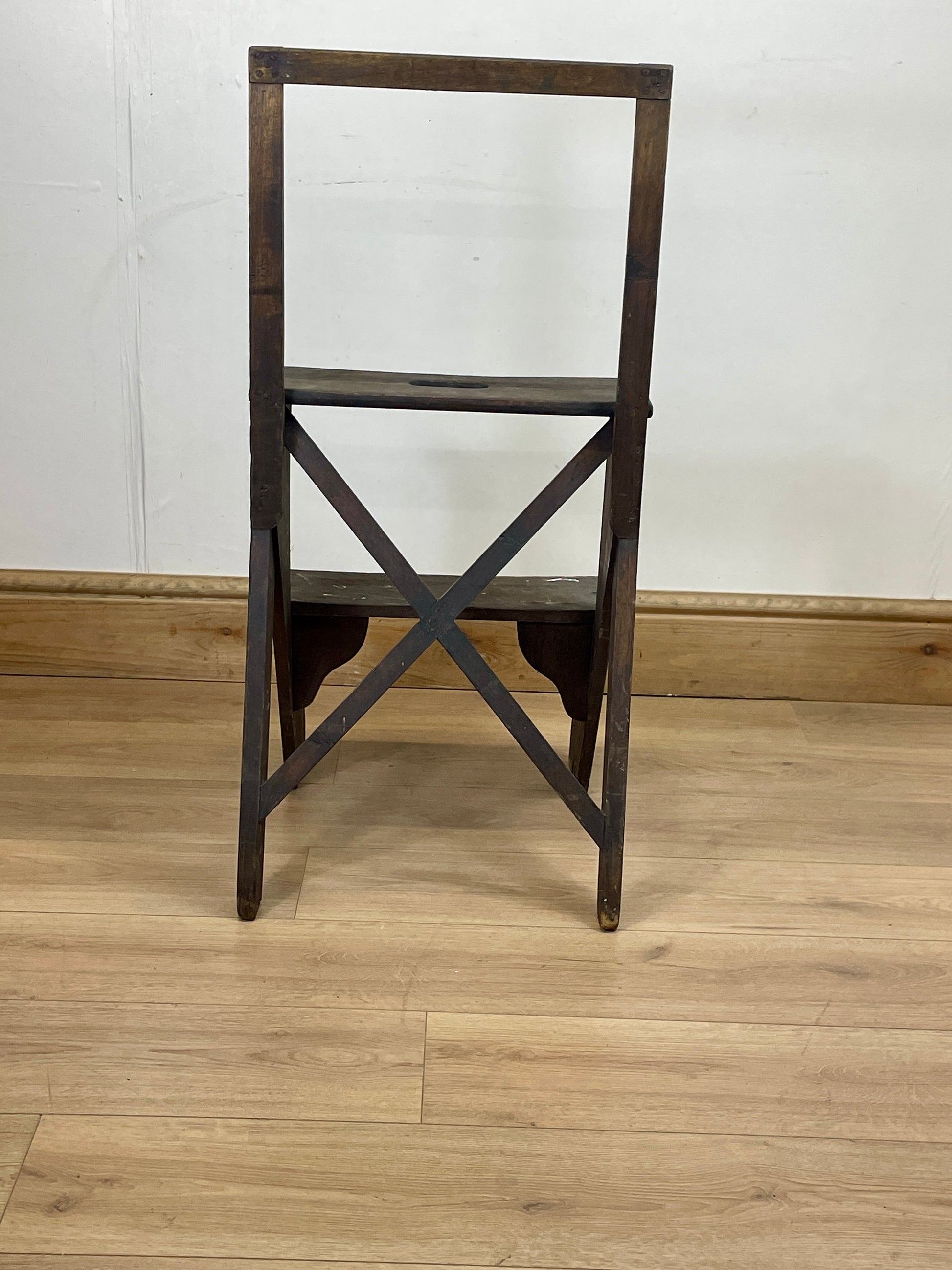 Wooden chair with a cross-back design on a wooden floor.