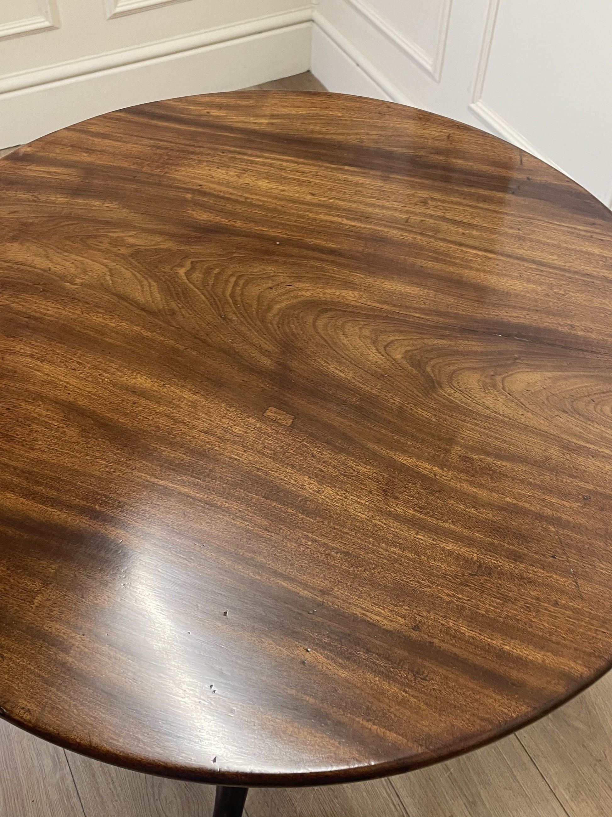 Round wooden table top with a dark brown finish.