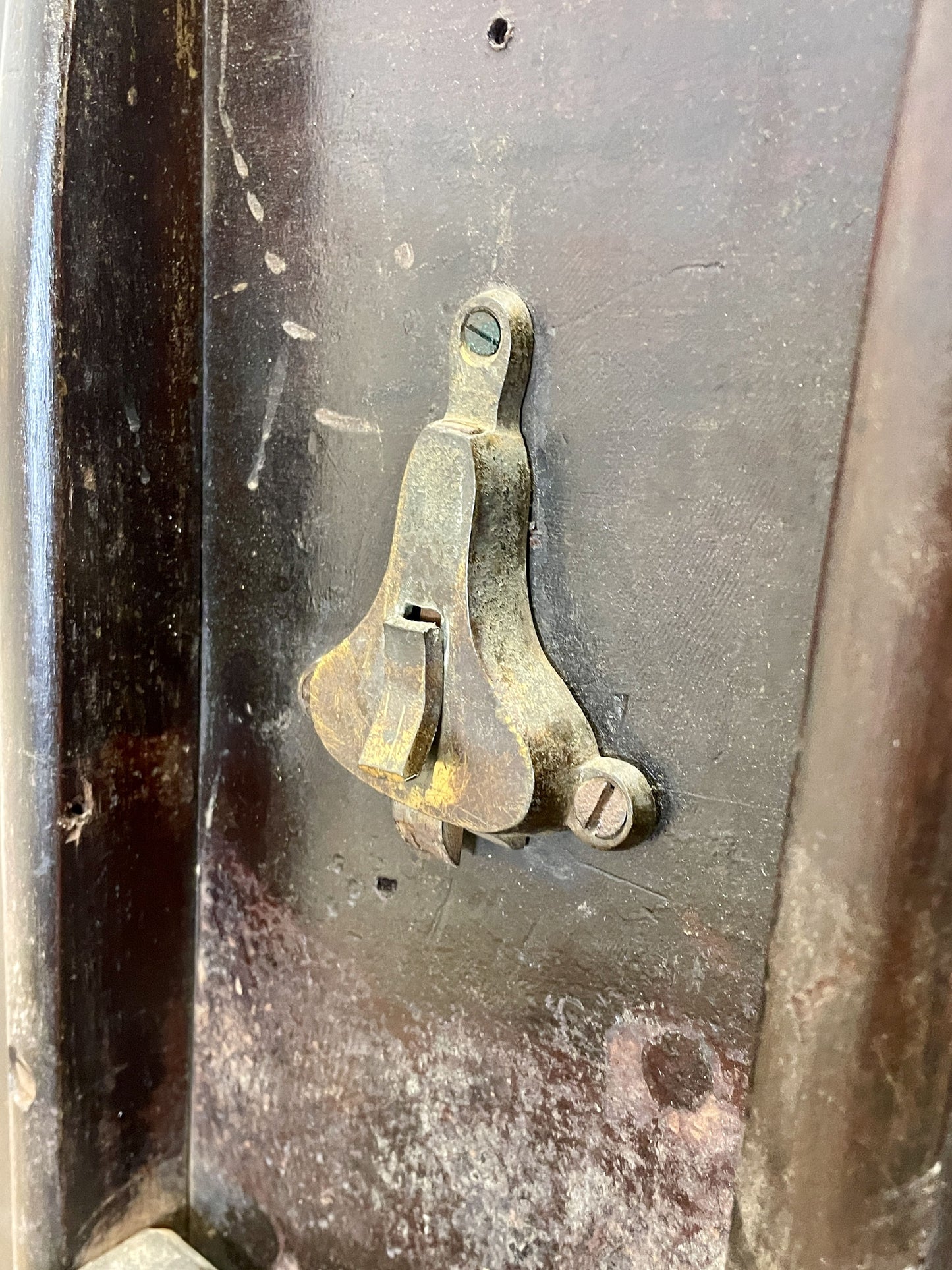 Rust-covered metal object with a small metallic bracket on a textured surface
