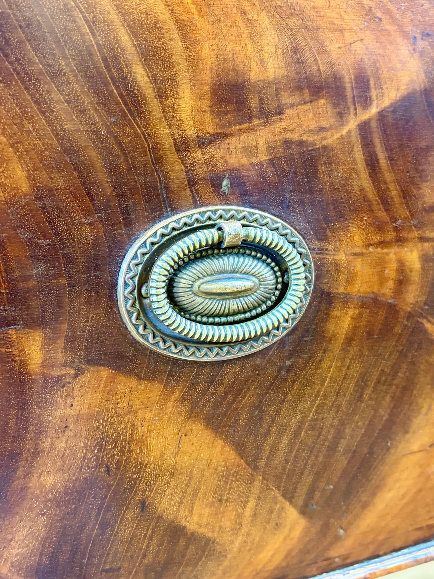 Front view of an antique Georgian mahogany small waterfall bookcase with two deep drawers