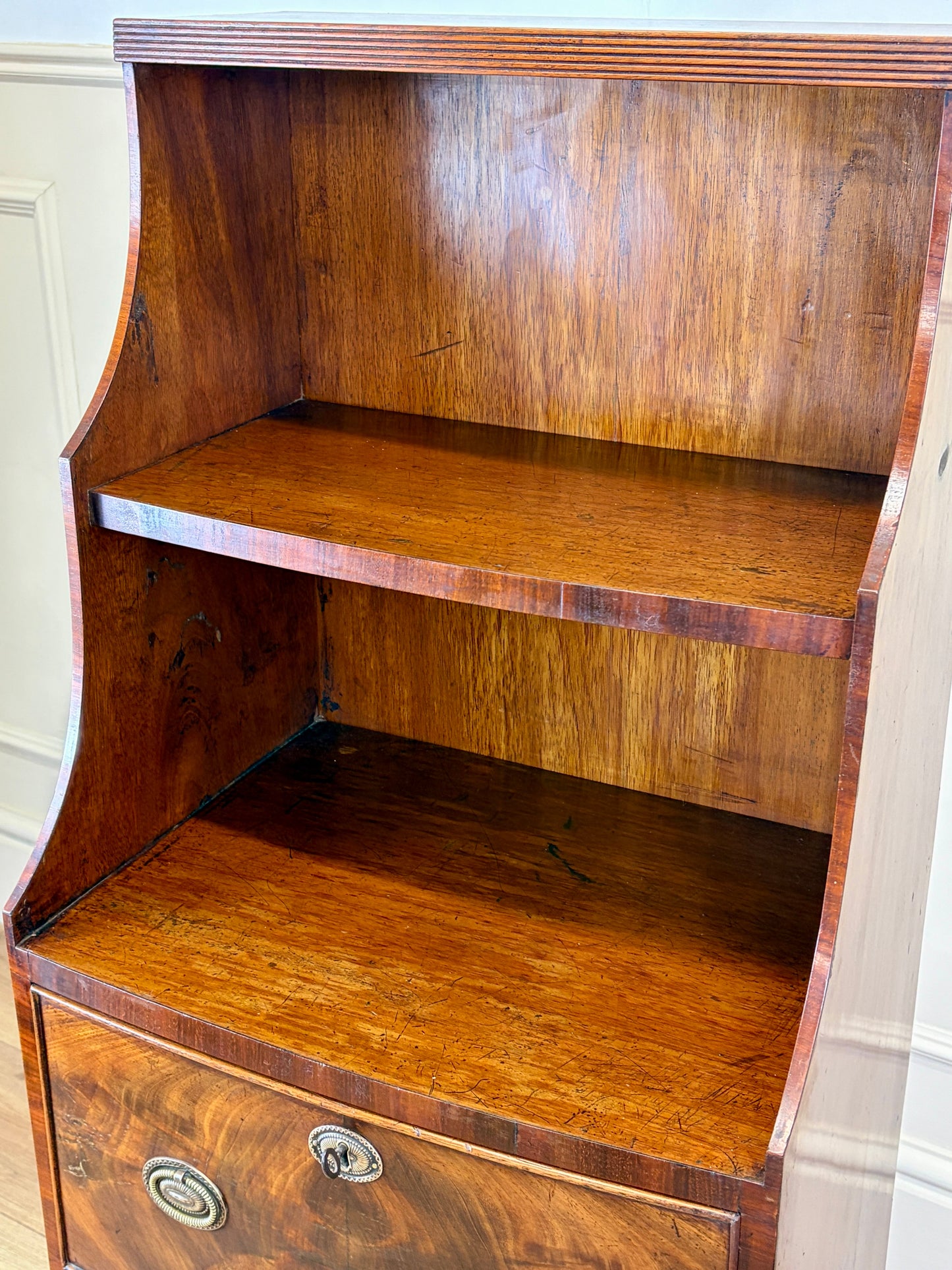 Front view of an antique Georgian mahogany small waterfall bookcase with two deep drawers