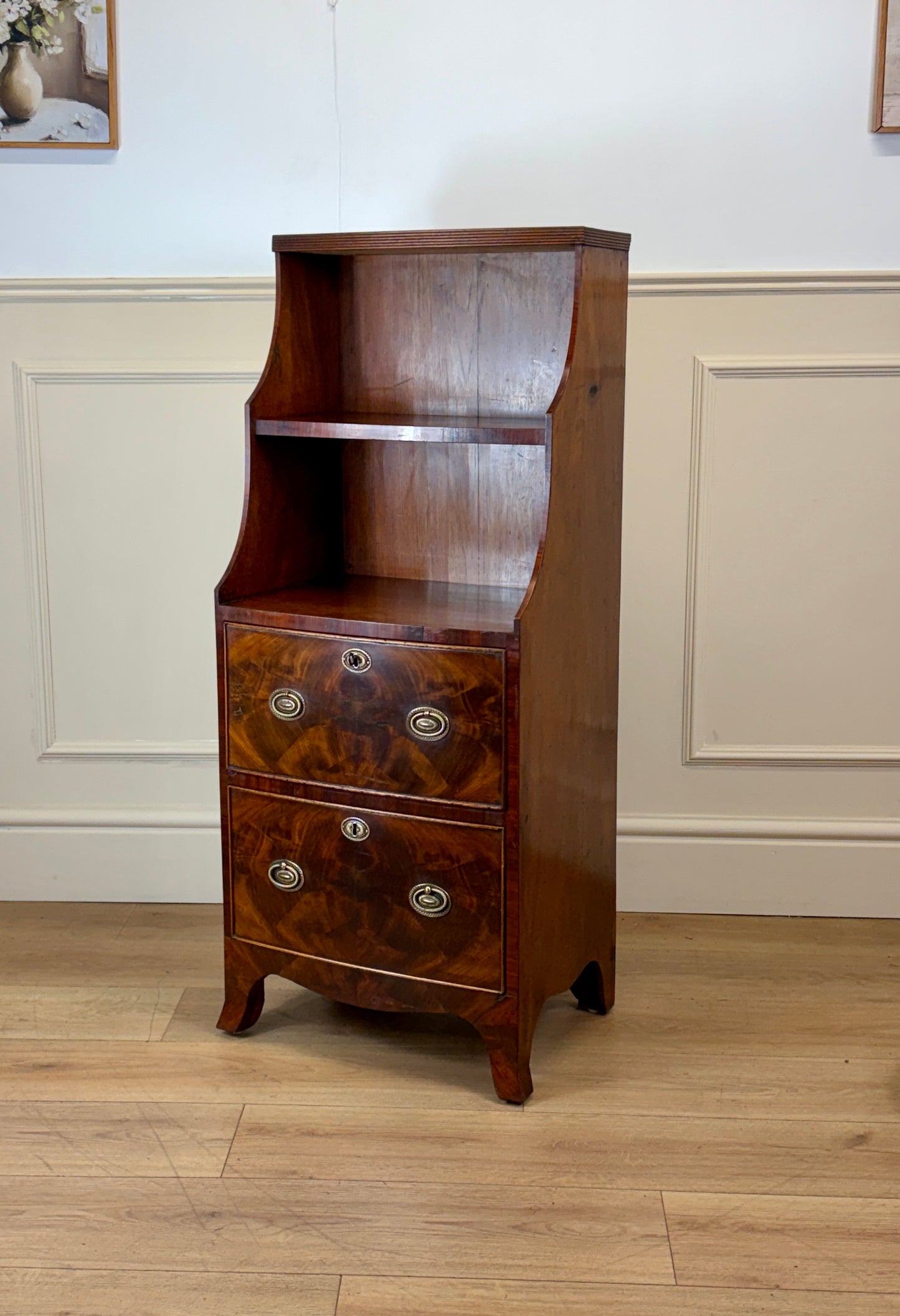 Front view of an antique Georgian mahogany small waterfall bookcase with two deep drawers