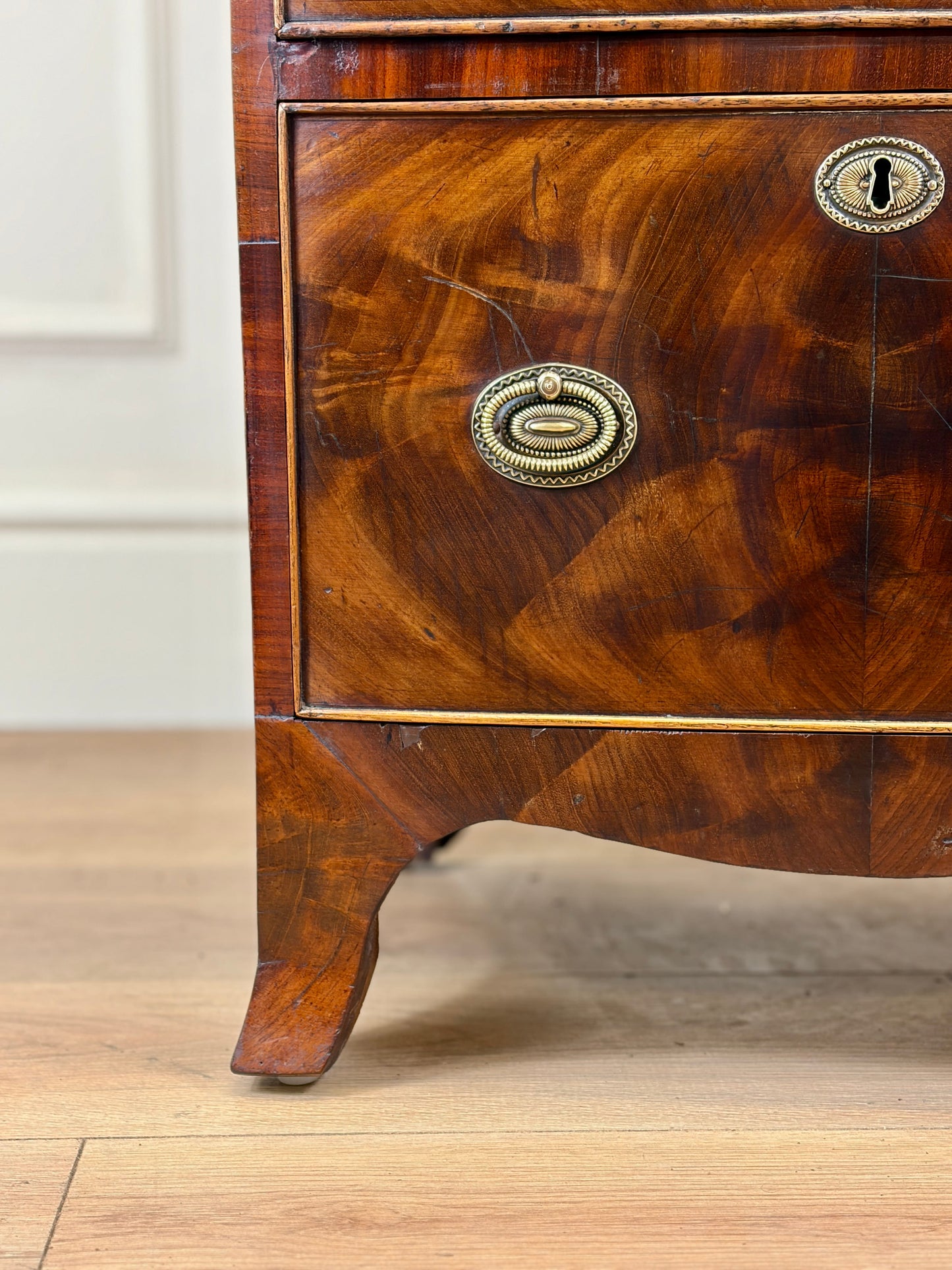 Front view of an antique Georgian mahogany small waterfall bookcase with two deep drawers