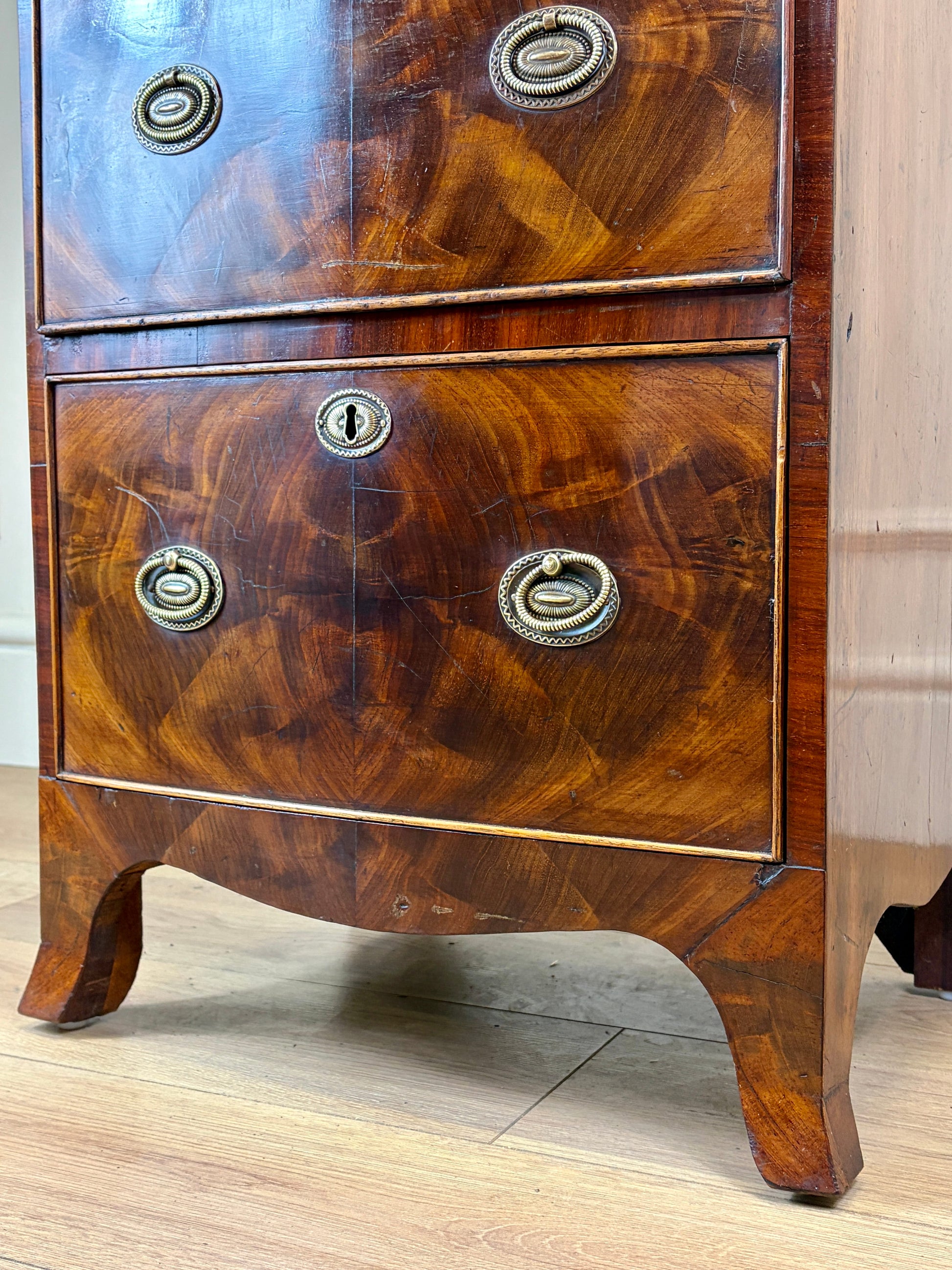 Front view of an antique Georgian mahogany small waterfall bookcase with two deep drawers