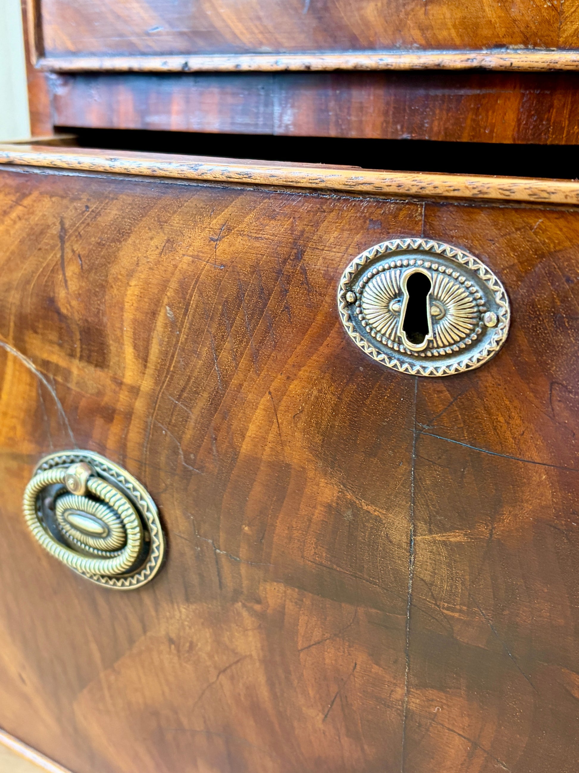 Front view of an antique Georgian mahogany small waterfall bookcase with two deep drawers