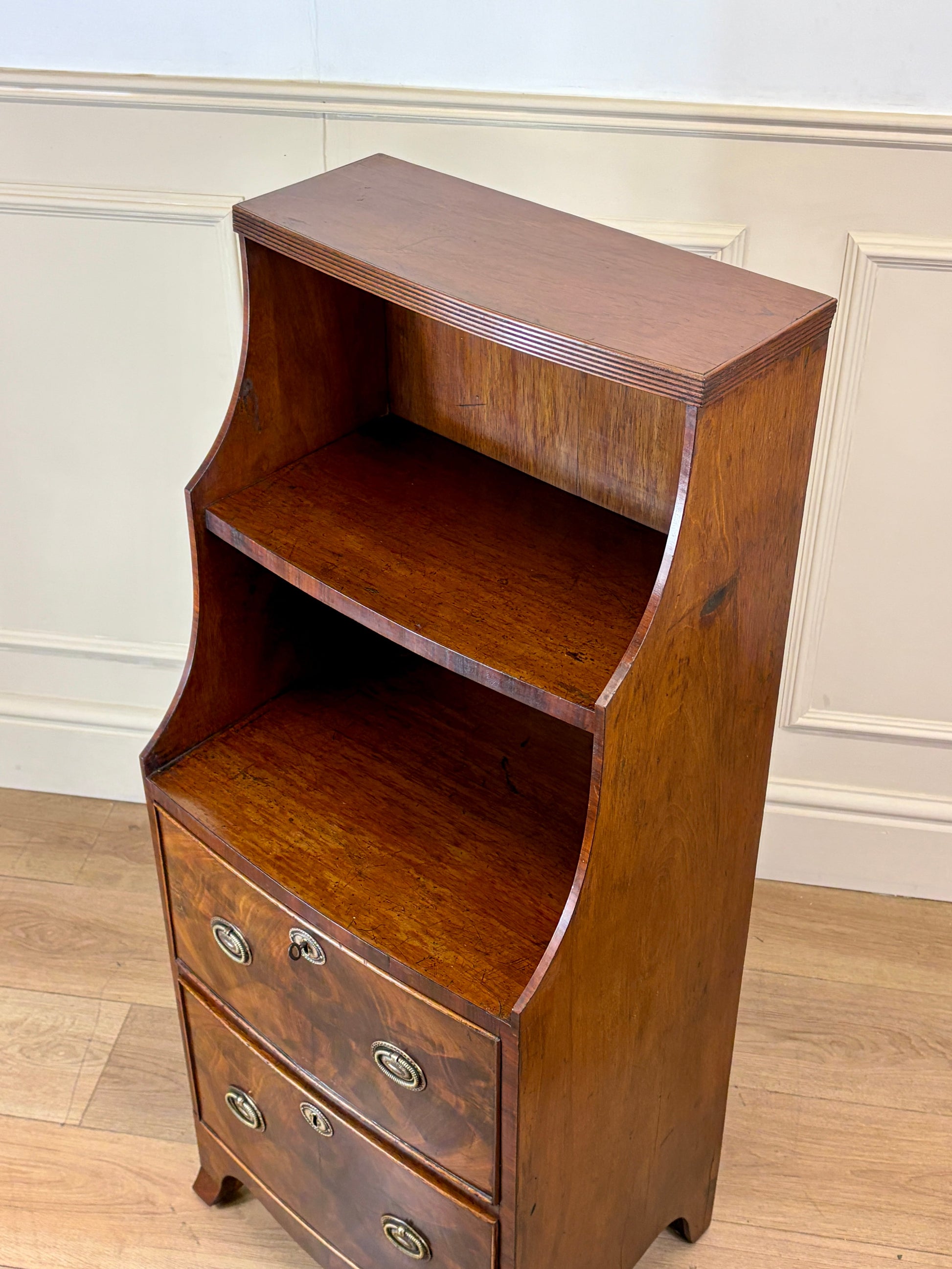 Front view of an antique Georgian mahogany small waterfall bookcase with two deep drawers