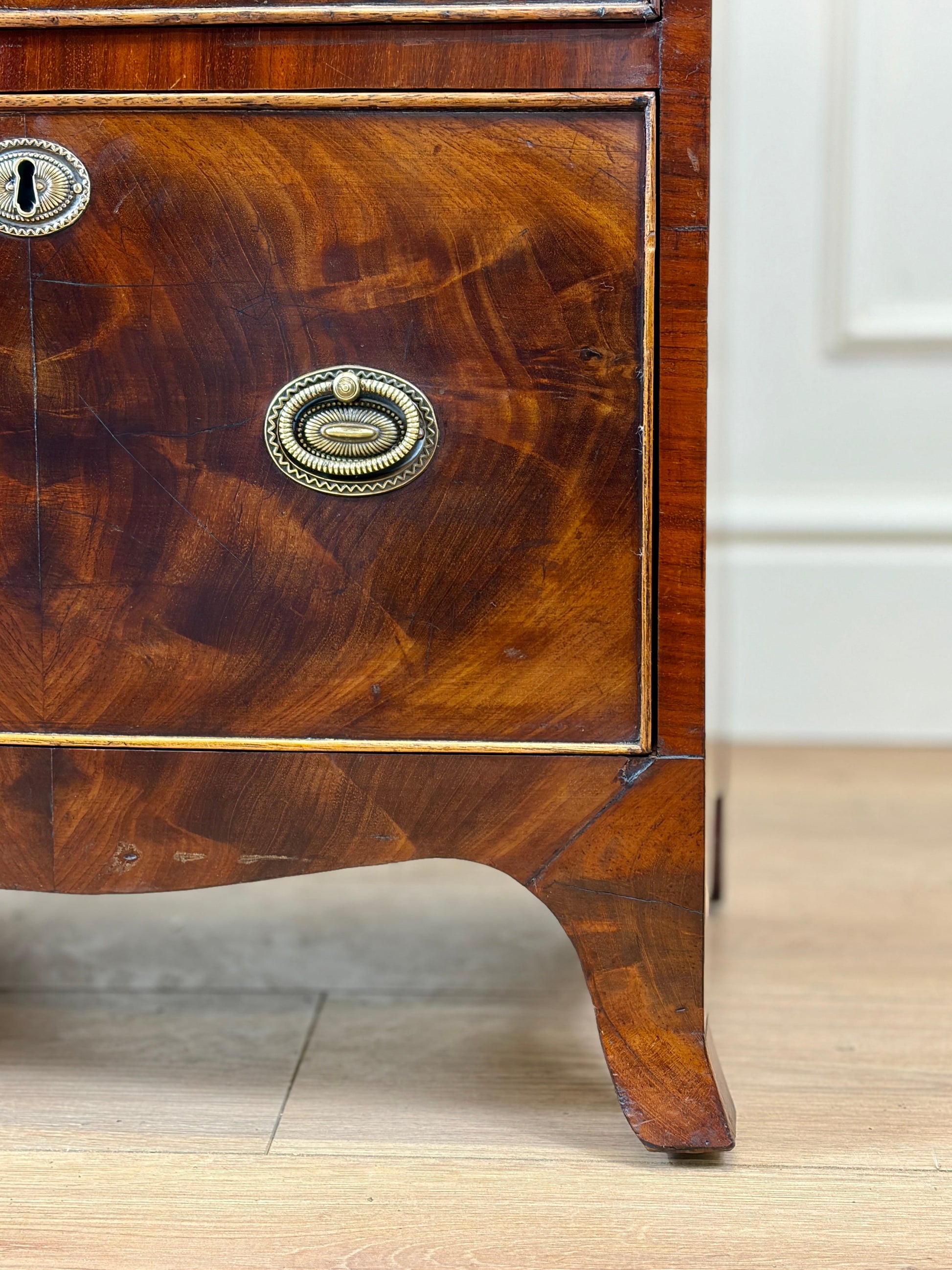 Front view of an antique Georgian mahogany small waterfall bookcase with two deep drawers