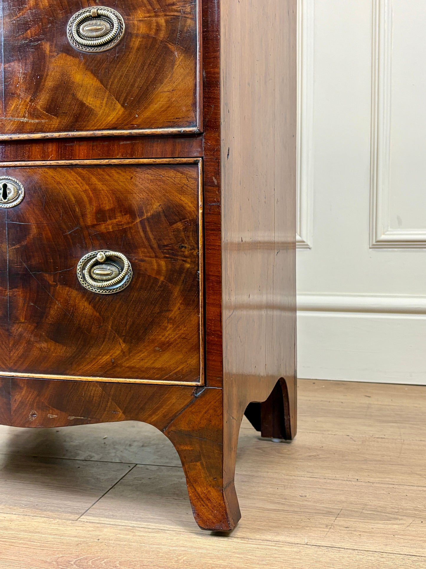 Front view of an antique Georgian mahogany small waterfall bookcase with two deep drawers