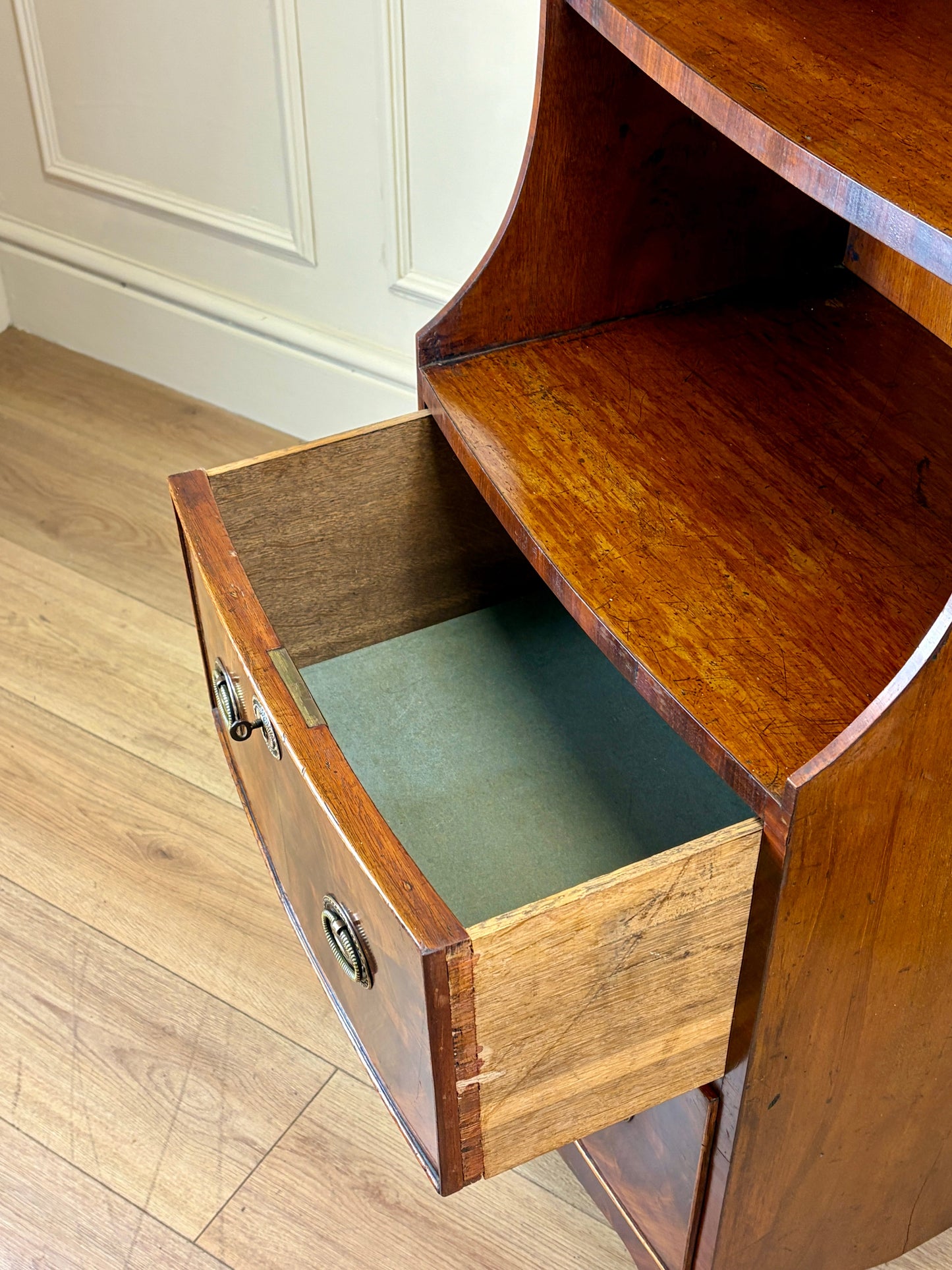 Front view of an antique Georgian mahogany small waterfall bookcase with two deep drawers