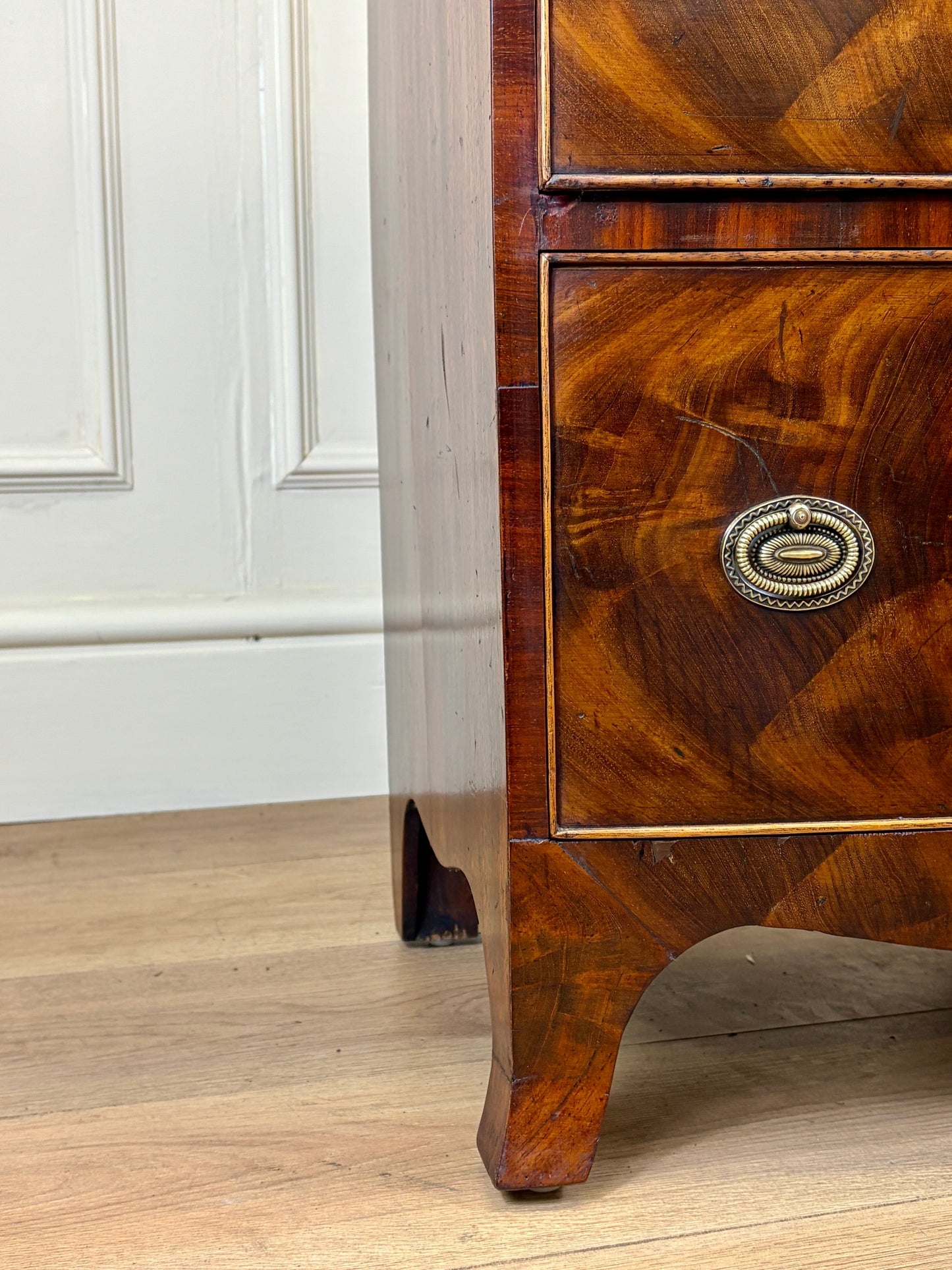 Front view of an antique Georgian mahogany small waterfall bookcase with two deep drawers