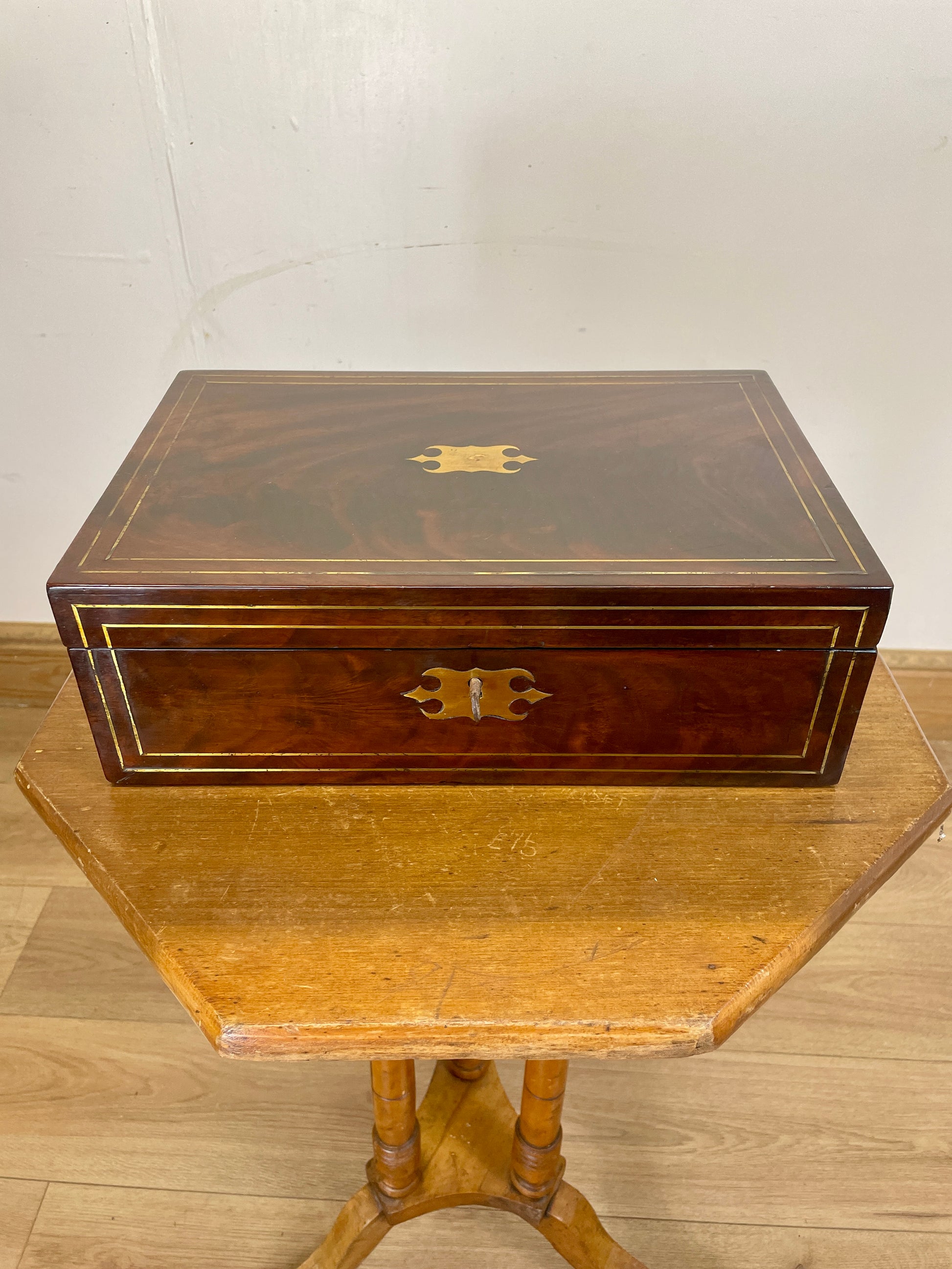 Wooden jewelry box on a wooden table with a plain background