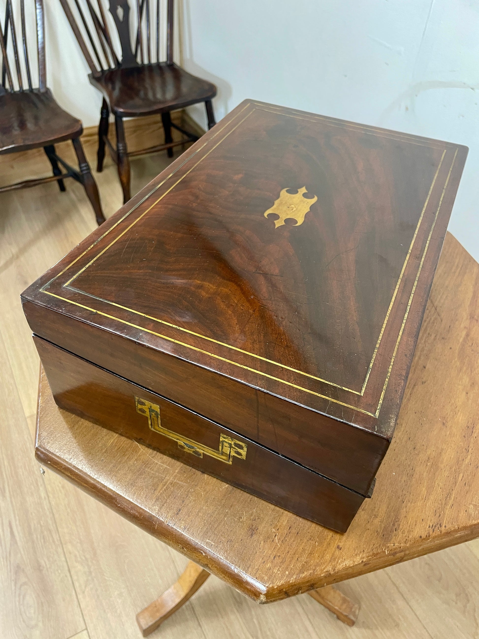 Wooden jewelry box with gold accents on a wooden table