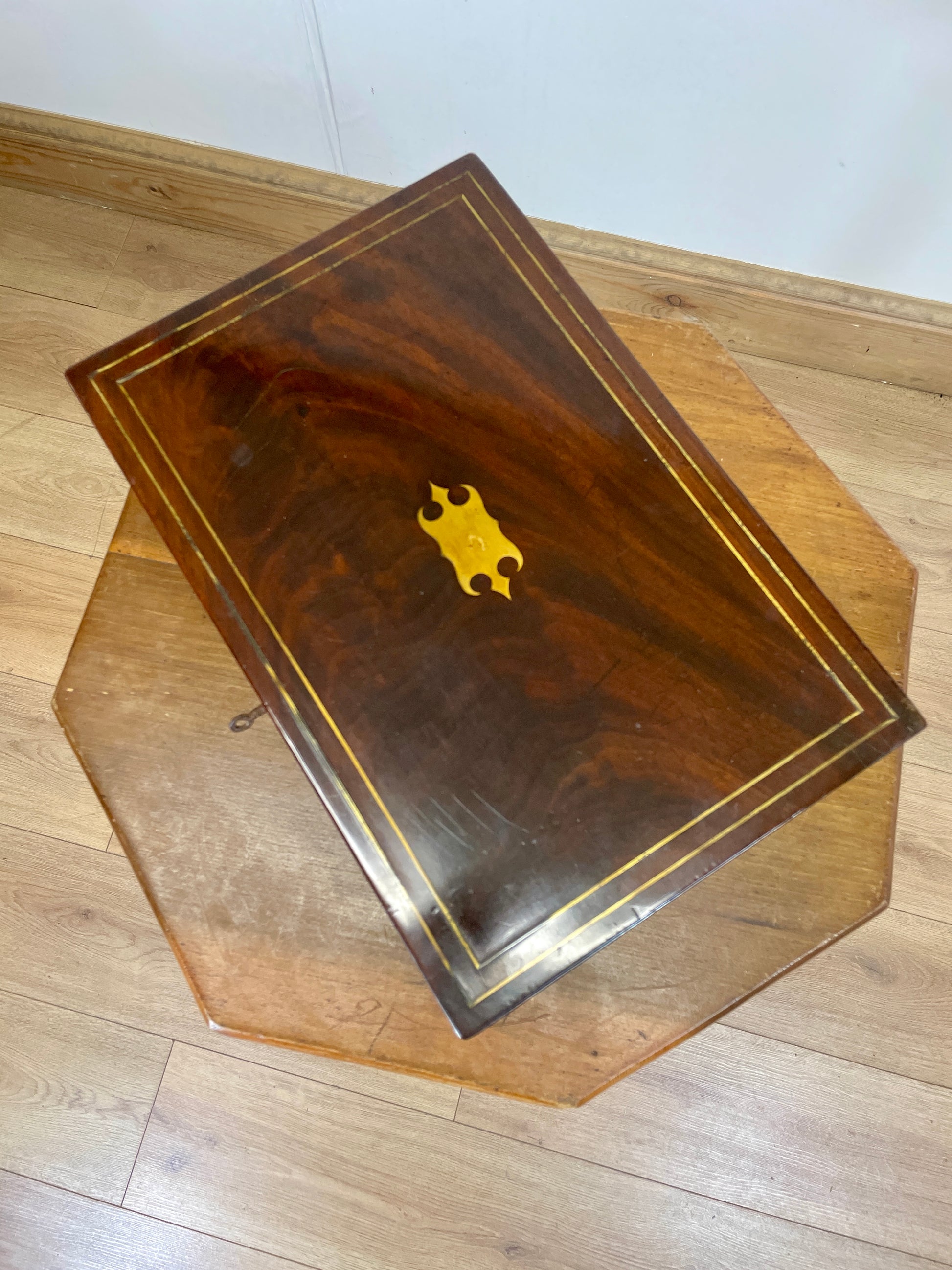 Wooden box with a metallic emblem on a wooden surface