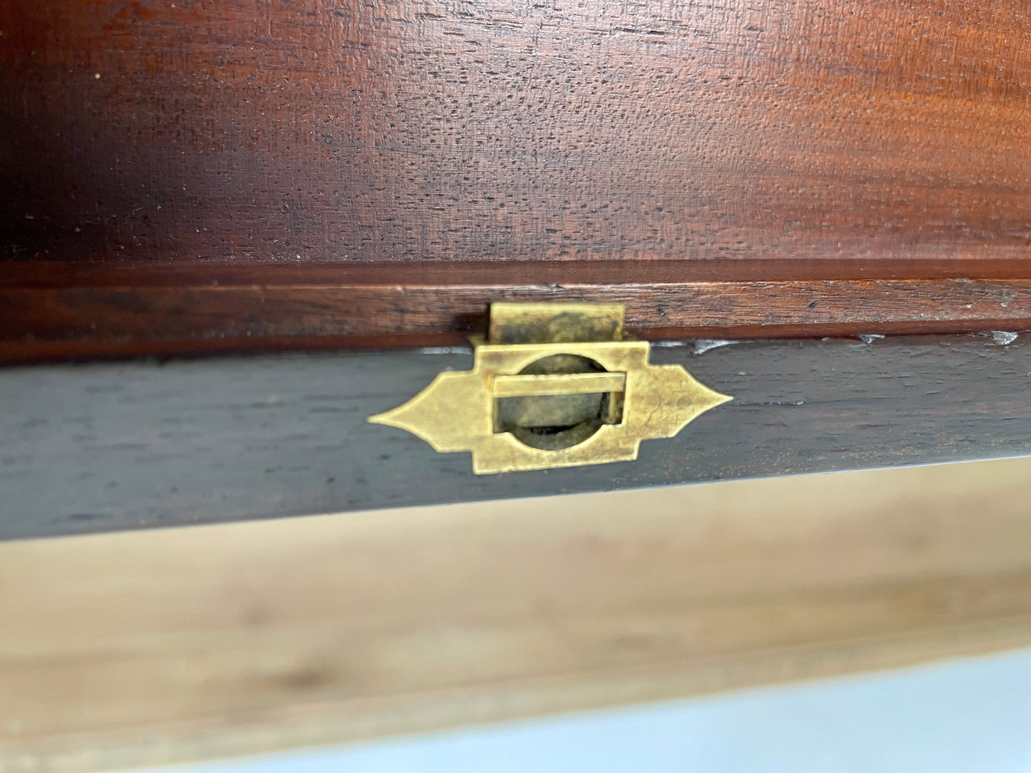 Close-up of a wooden box with a brass latch on a white background