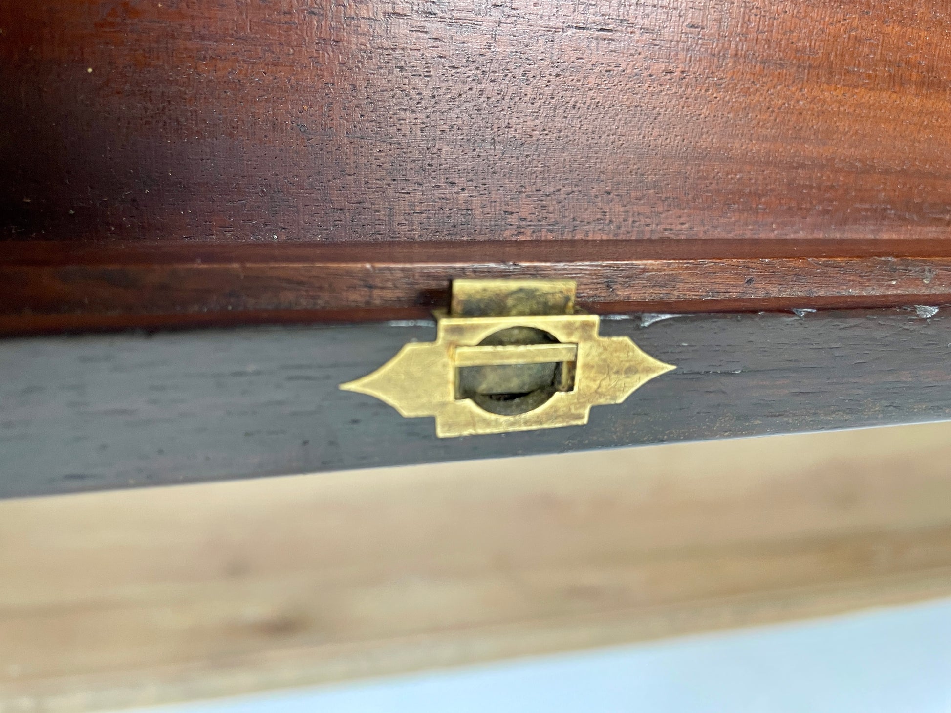 Close-up of a wooden box with a brass latch on a white background