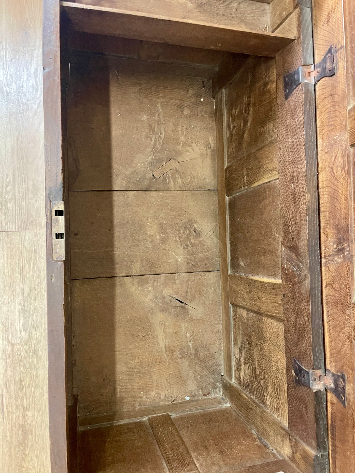 Wooden cabinet with a door open, showing interior shelves.