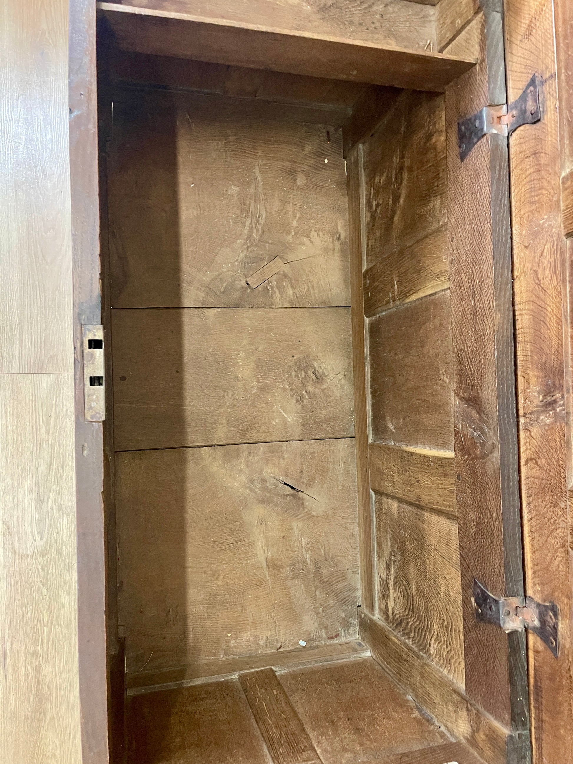 Wooden cabinet with a door open, showing interior shelves.