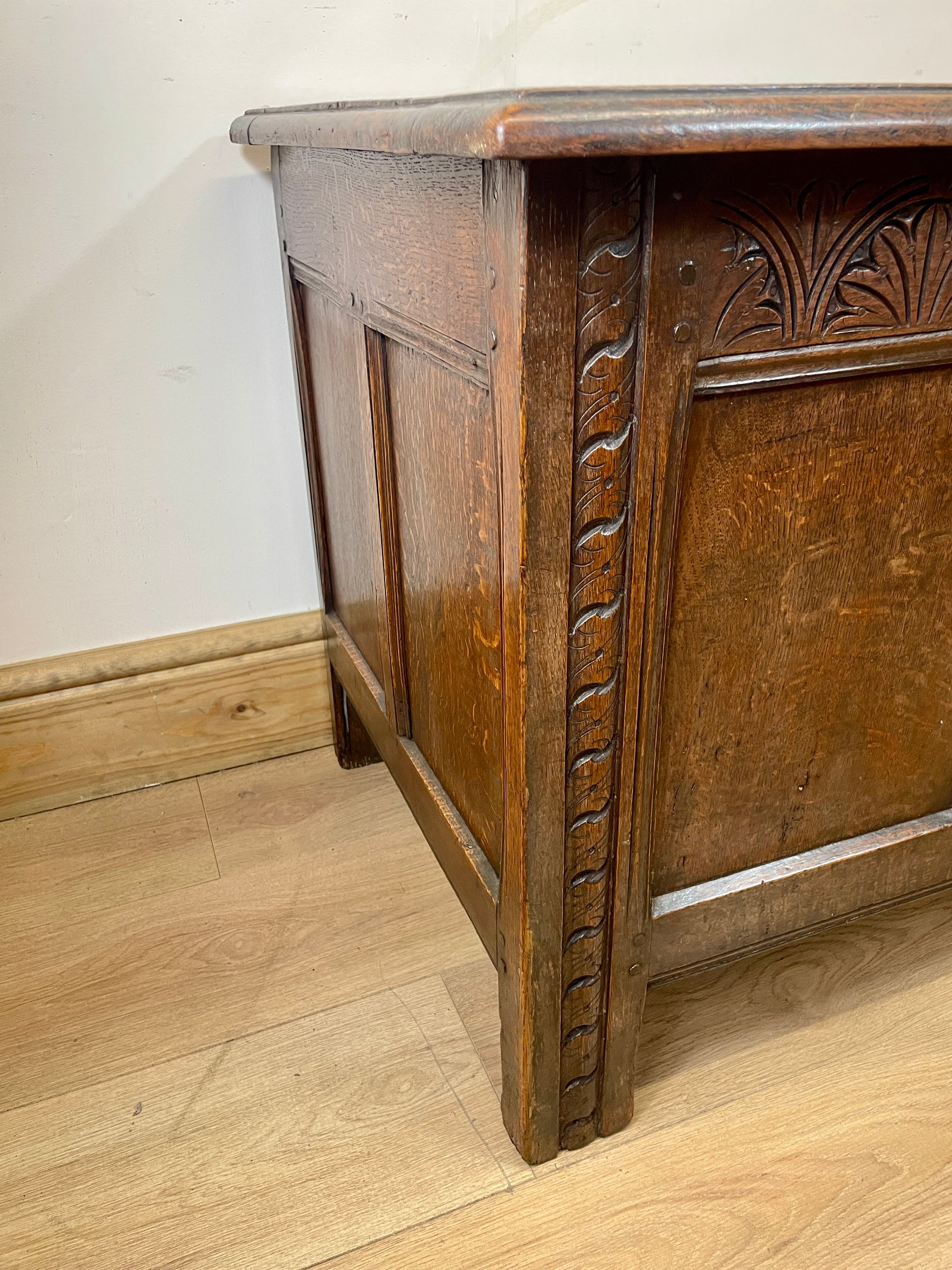 Wooden cabinet with intricate carvings on a wooden floor.
