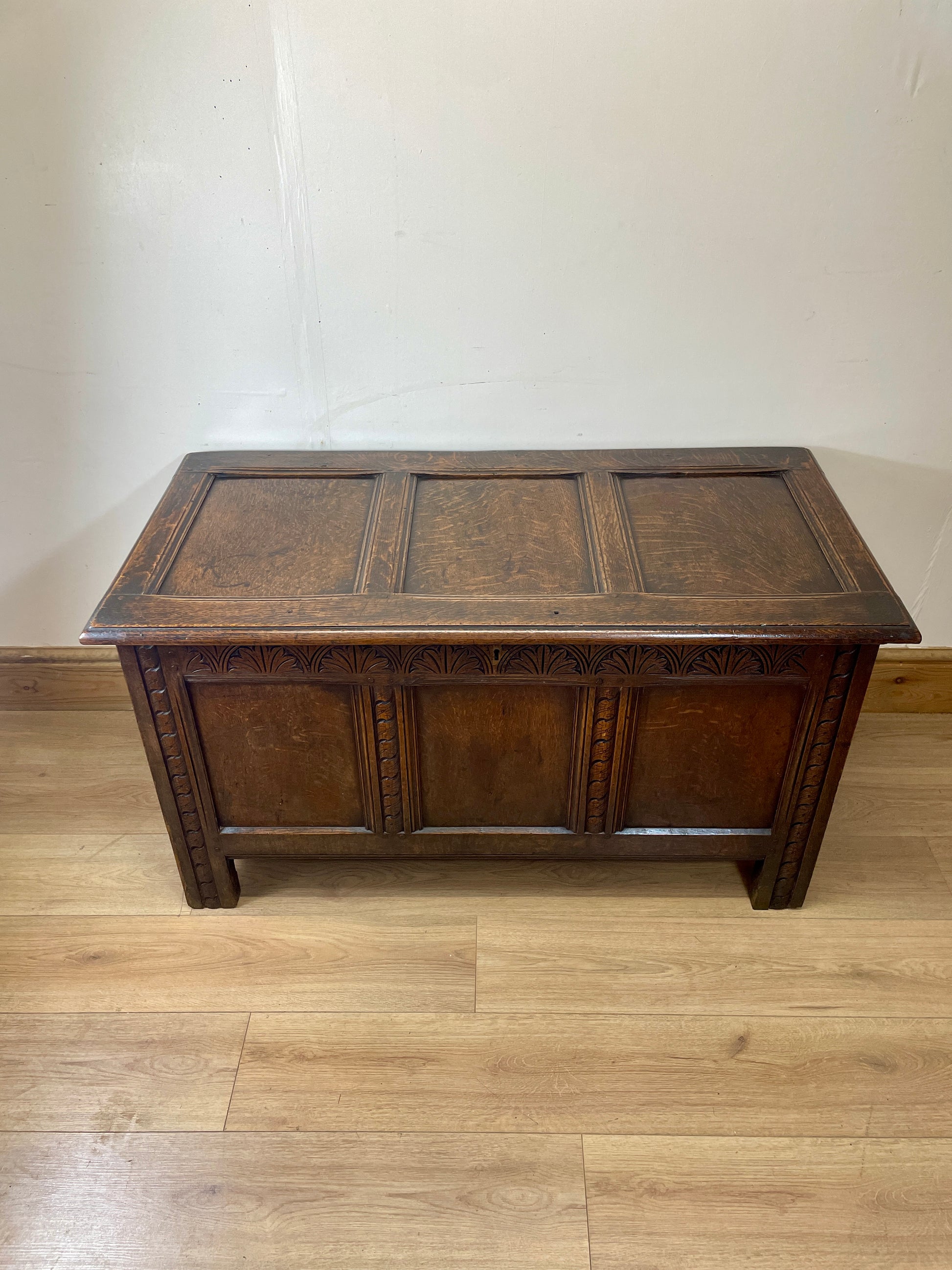 Wooden chest on a wooden floor with a white wall background