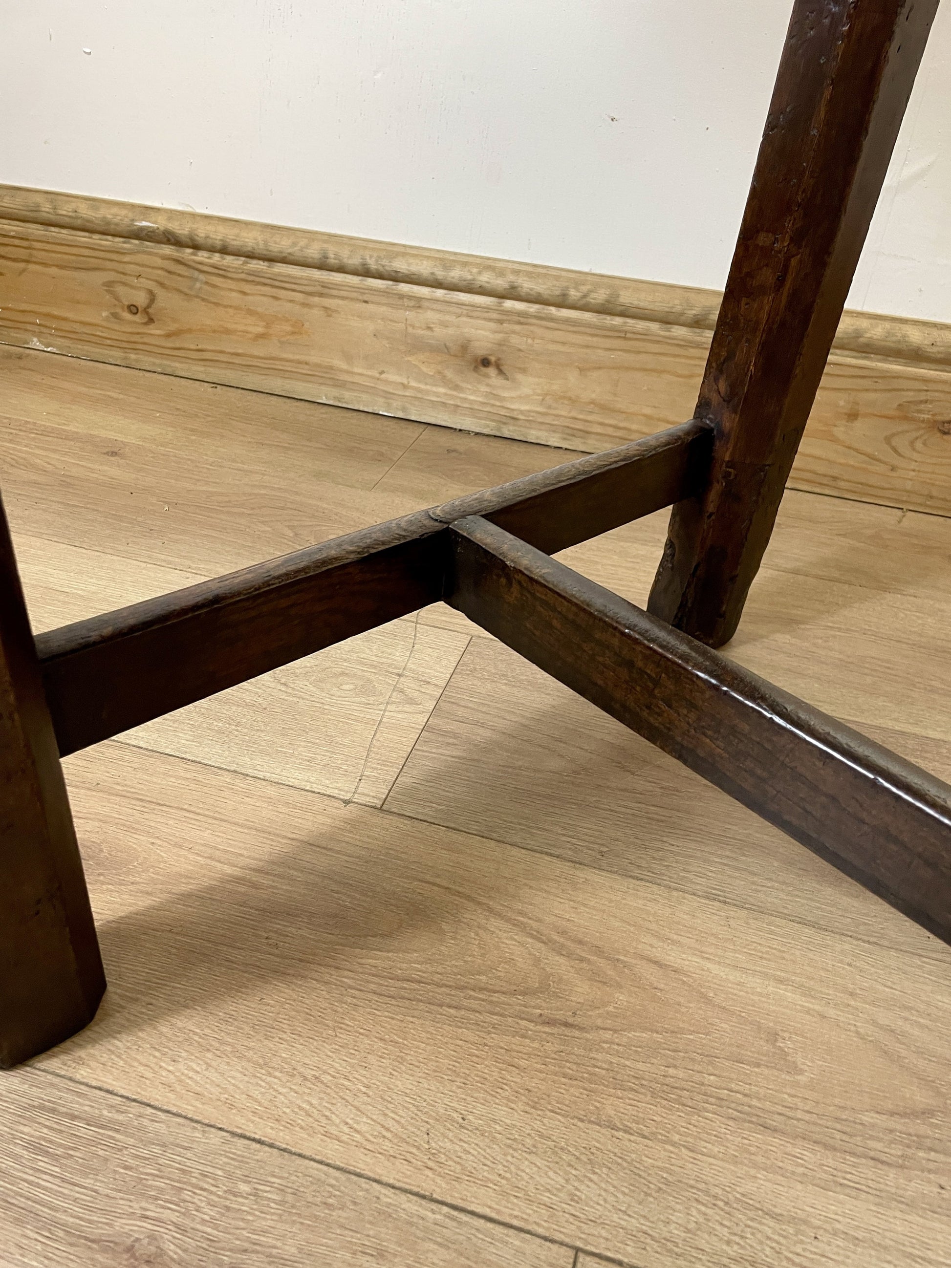 Wooden chair seat and leg on a wooden floor