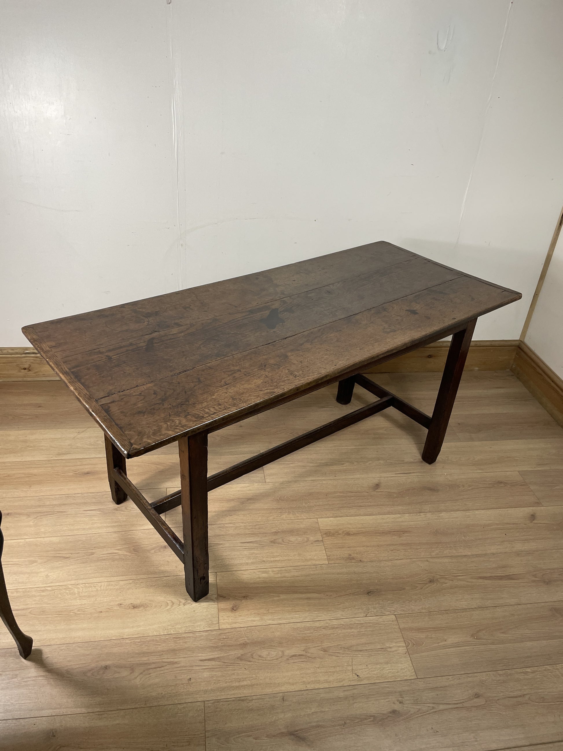 Wooden table on a wooden floor with a white wall background