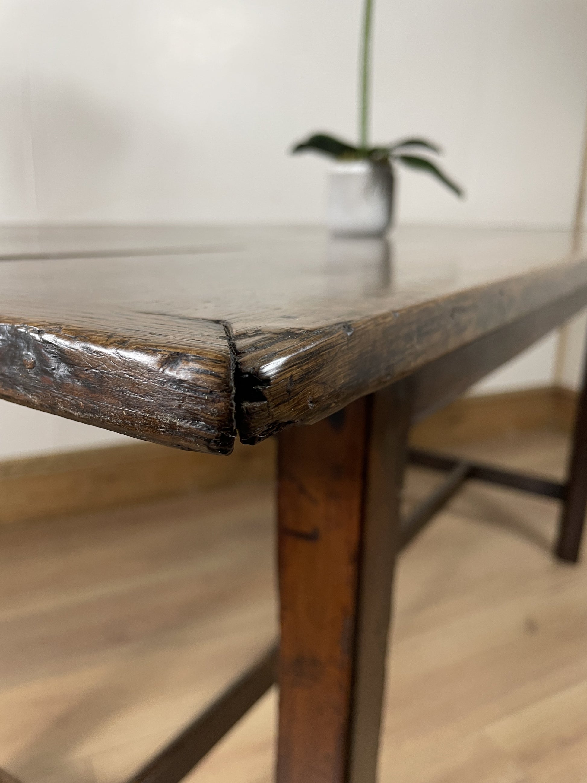 Close-up of a wooden table with a crack, blurred background