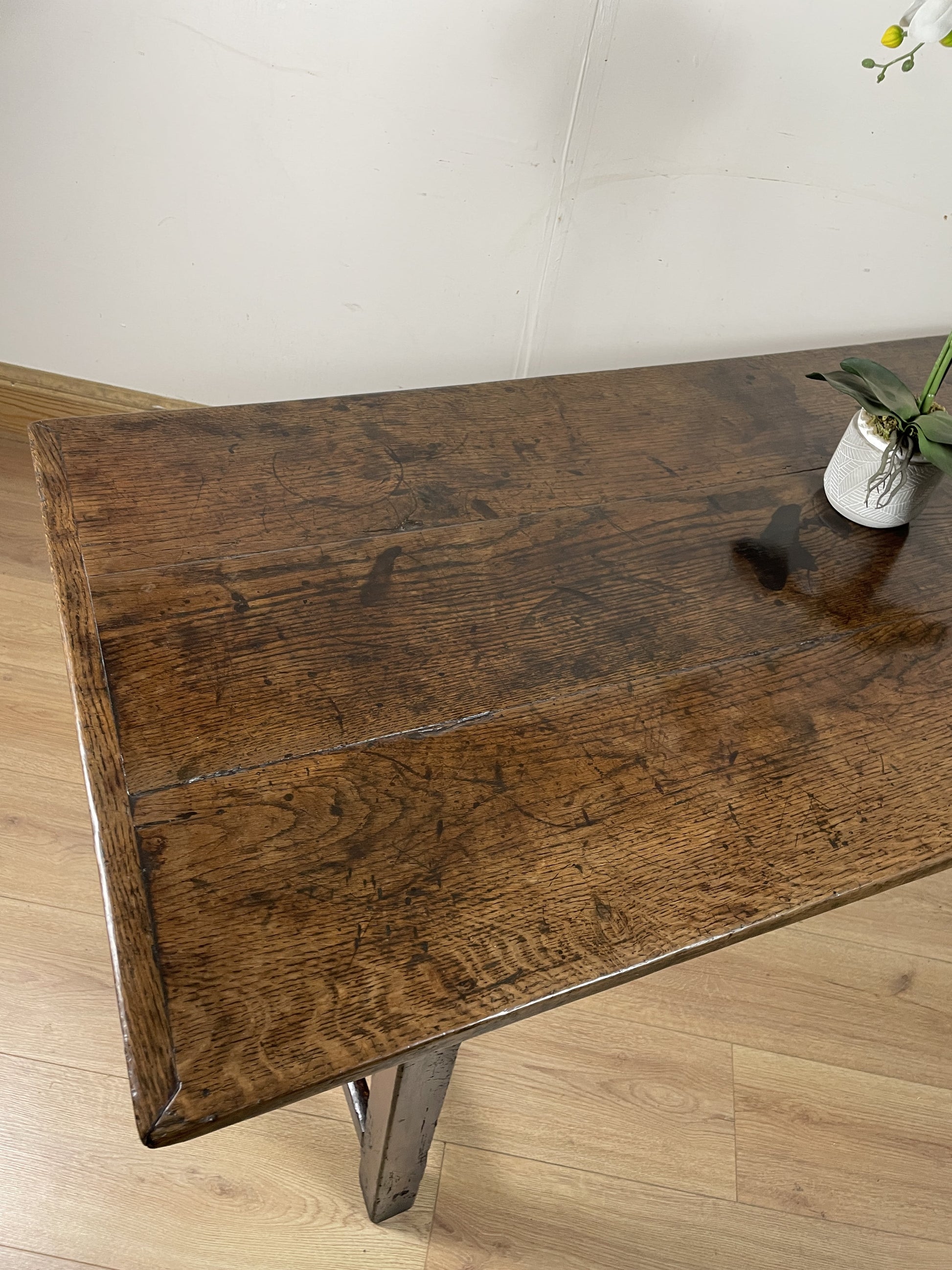 Wooden table with a rustic finish on a light wooden floor.