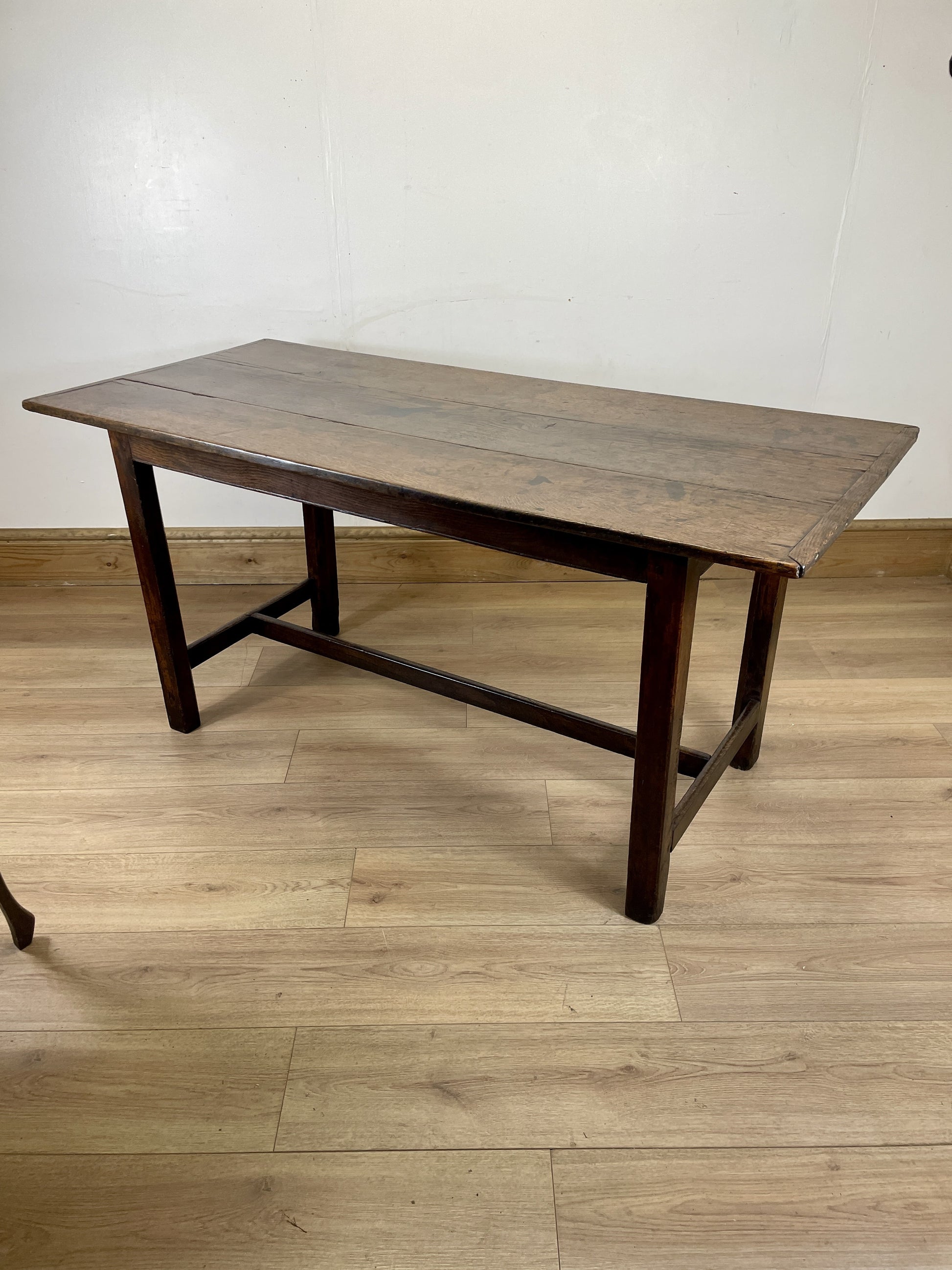 Wooden table on a wooden floor with a white wall background