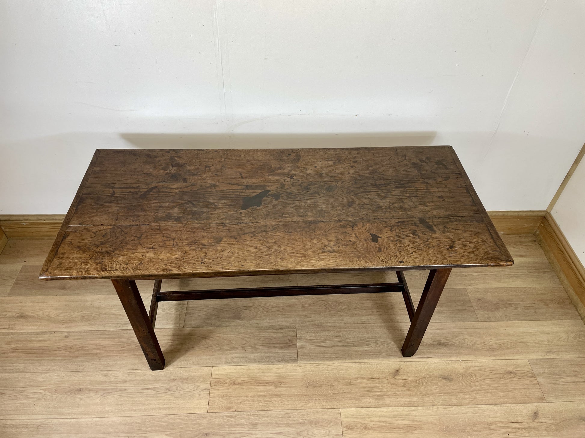 Vintage wooden table against a white wall on a wooden floor