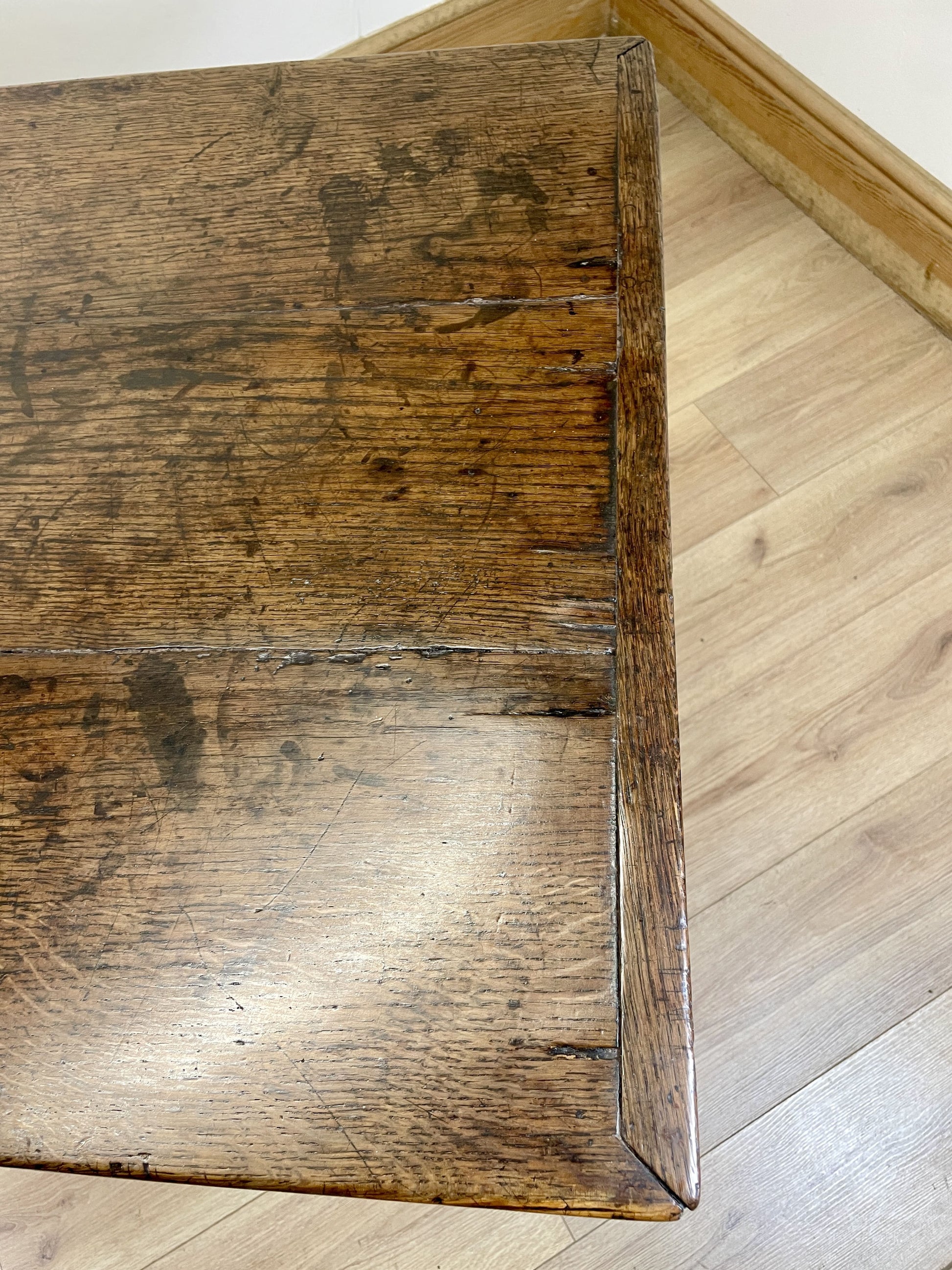 Corner of a wooden table on a wooden floor