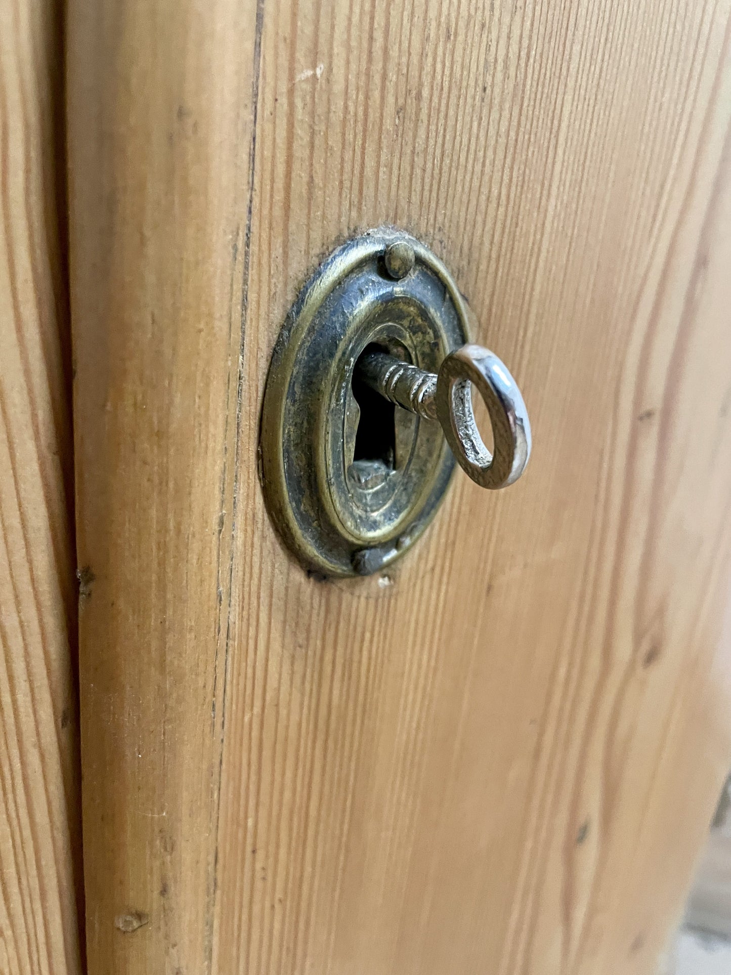 Close-up of a wooden door with a brass lock and keyhole.