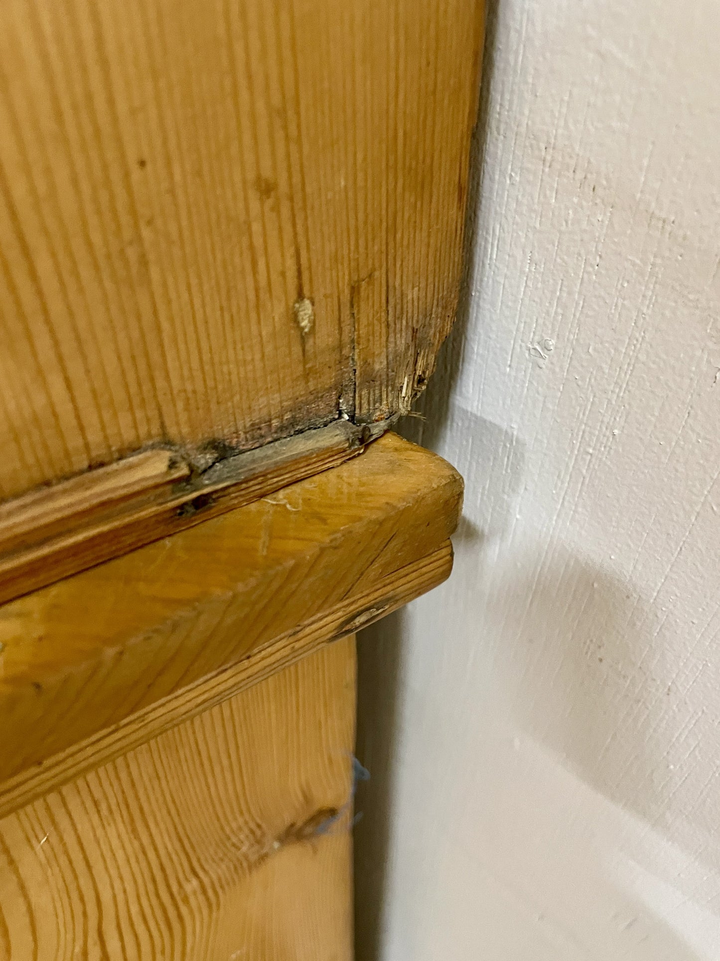 Wooden door with a gap between it and the wall