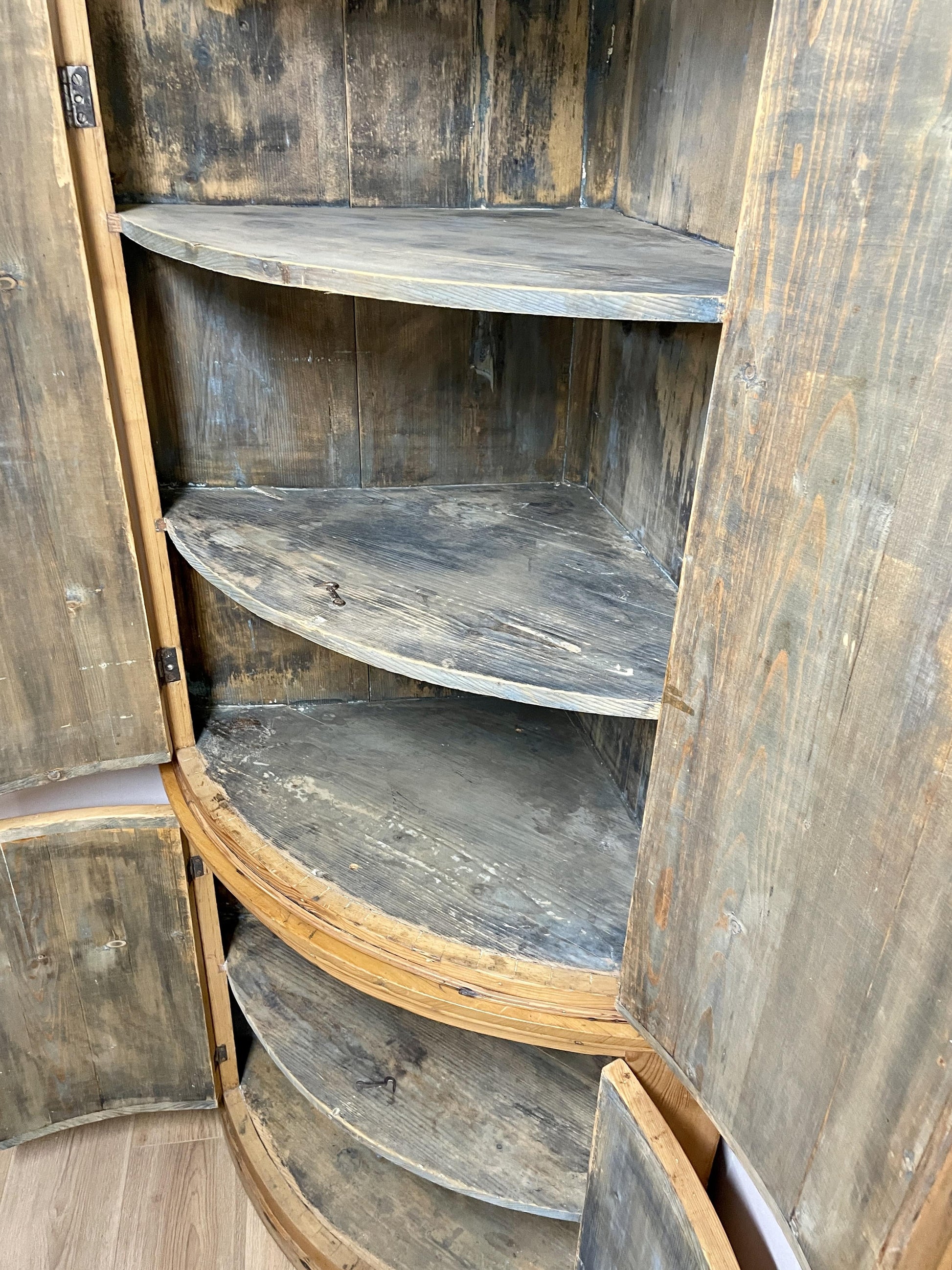 Wooden corner cabinet with curved shelves in a rustic style
