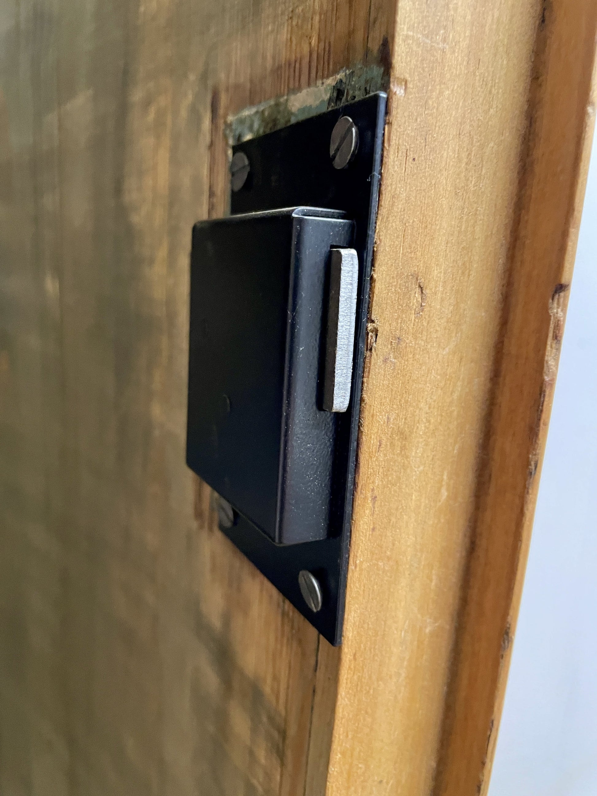 Black door latch on a wooden door