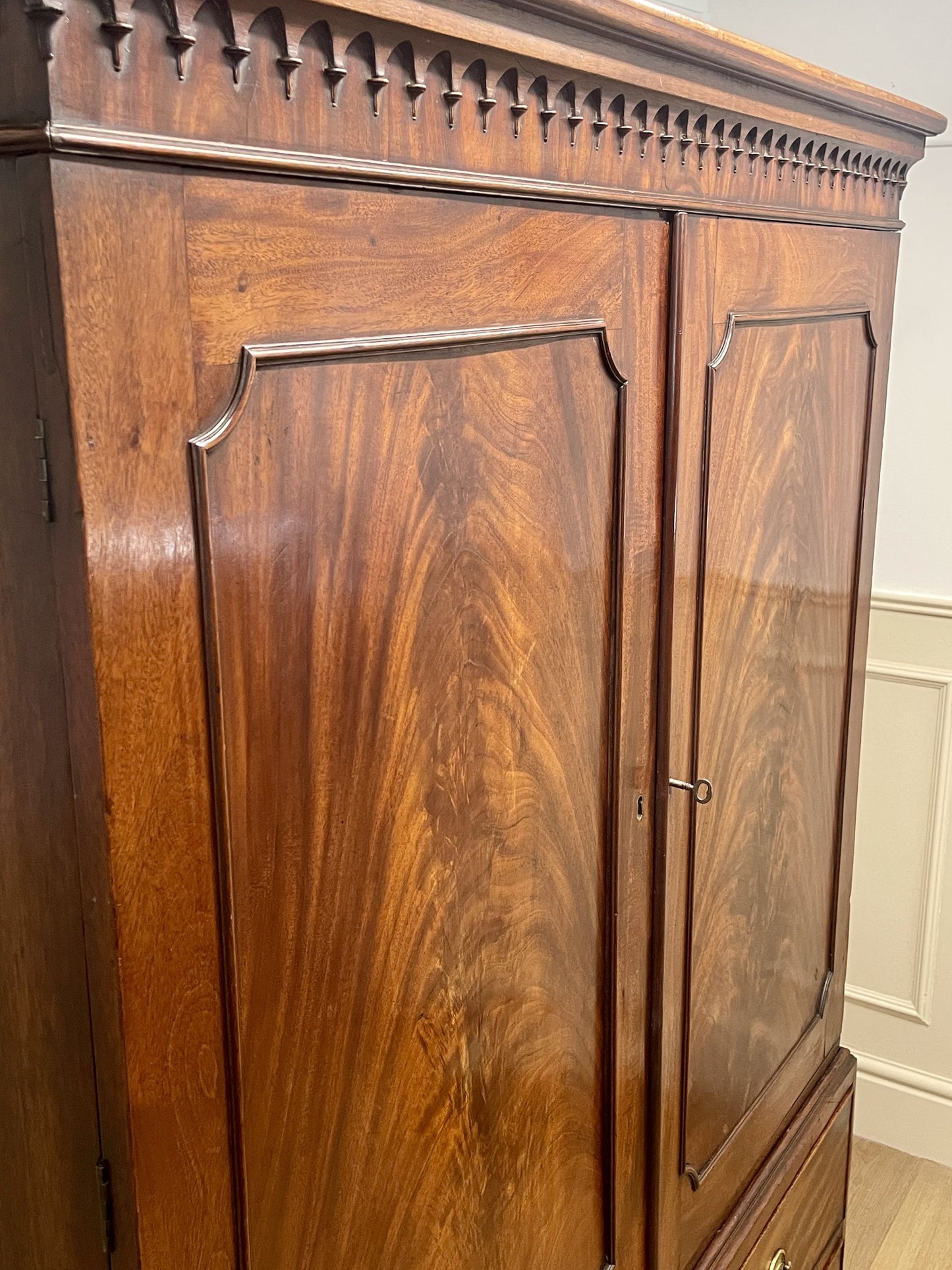 Wooden wardrobe with intricate carvings on a white wall background