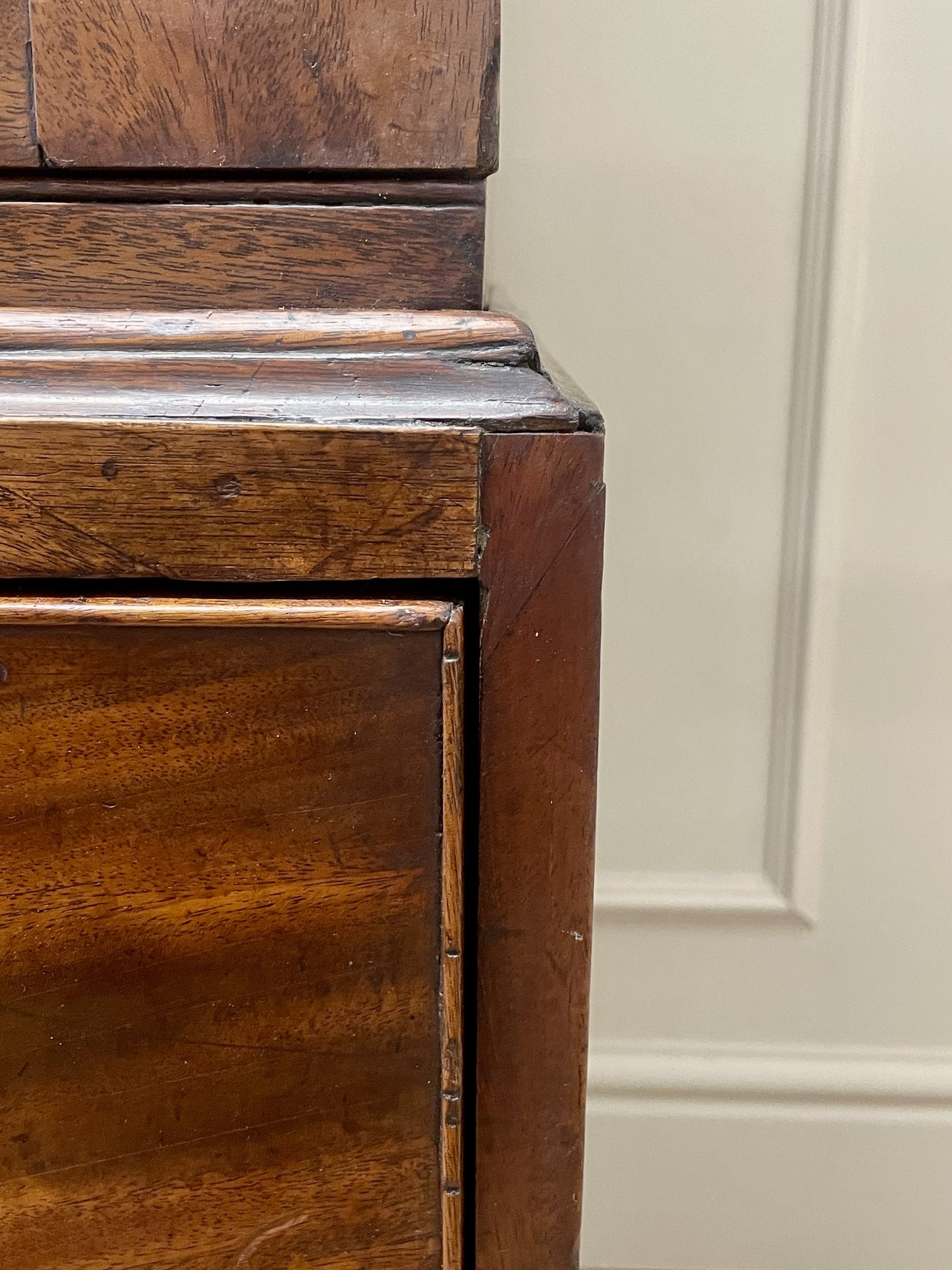 Close-up of a wooden cabinet corner with a neutral background